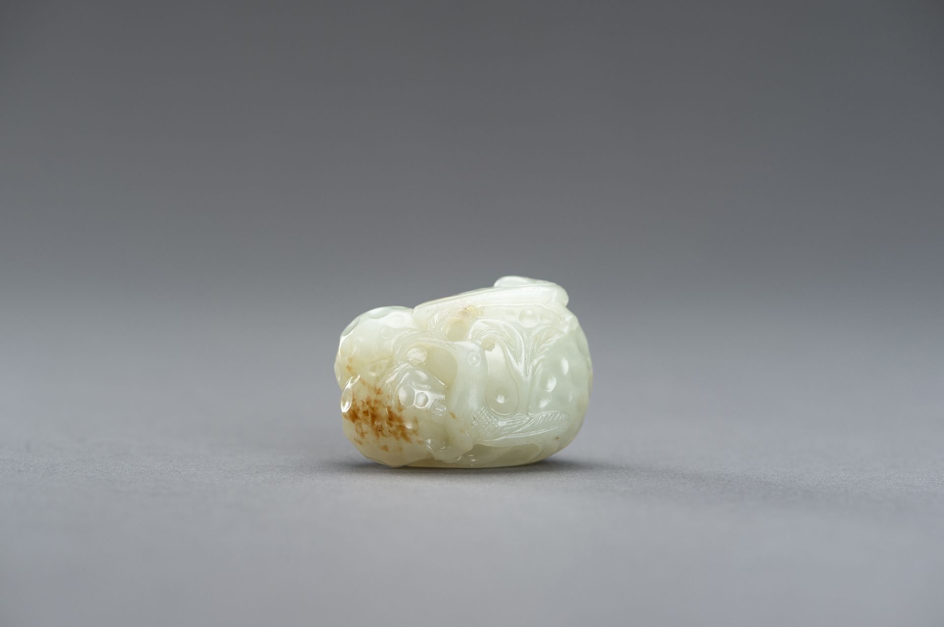 A CELADON JADE PENDANT OF A LYCHEE WITH BIRDS, 1920s - Image 3 of 9