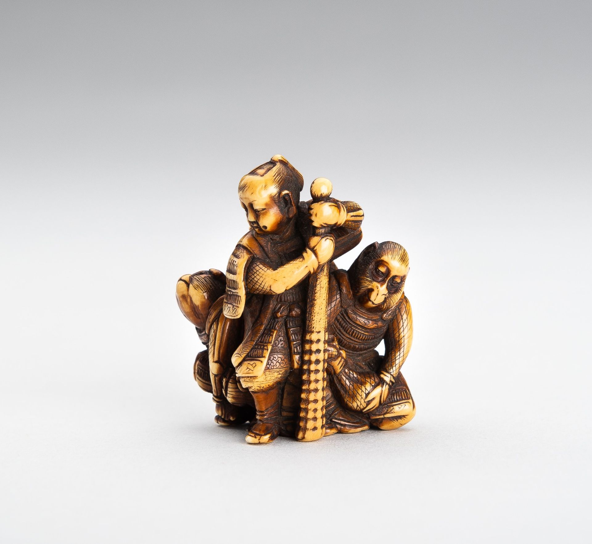 TOMOCHIKA: AN IVORY NETSUKE OF MOMOTARO WITH COMPANIONS