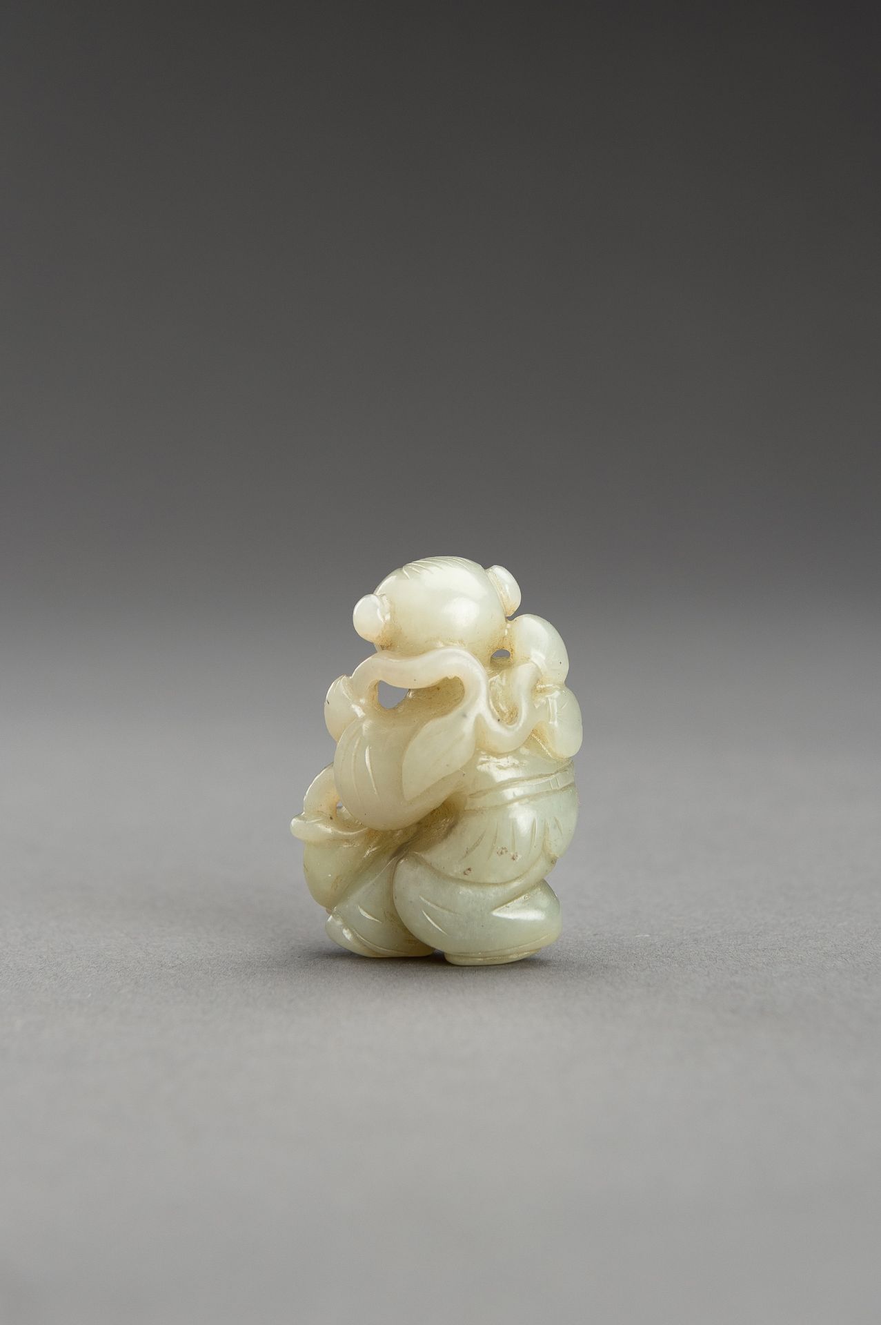 A SMALL PALE CELADON JADE FIGURE OF A BOY - Bild 8 aus 9