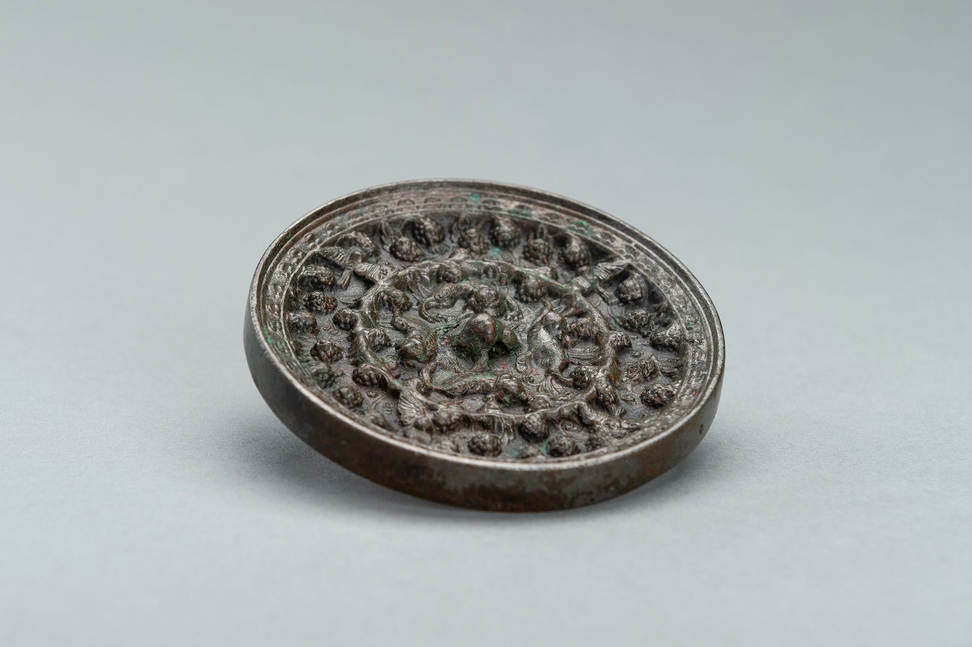 A SILVERY TANG DYNASTY BRONZE 'LION AND GRAPEVINE' MIRROR - Image 7 of 9