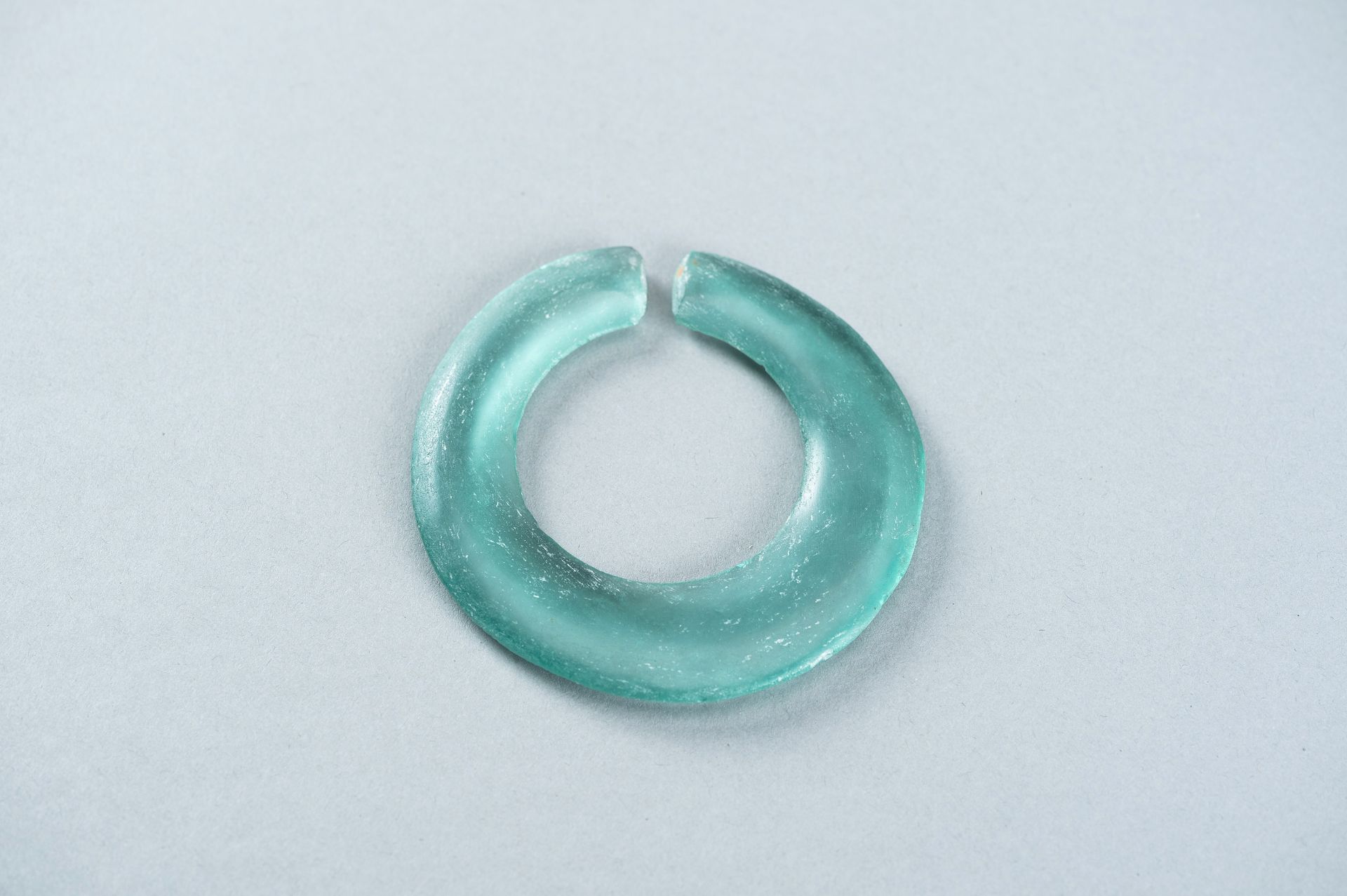 AN ARCHAIC PALE GREEN GLASS DISC - Image 9 of 9