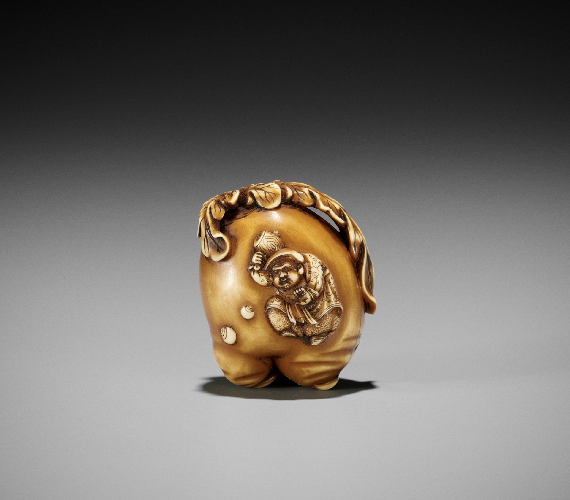 MITSUSADA: A FINE IVORY NETSUKE OF A DAIKON (FORKED RADISH) WITH DAIKOKU