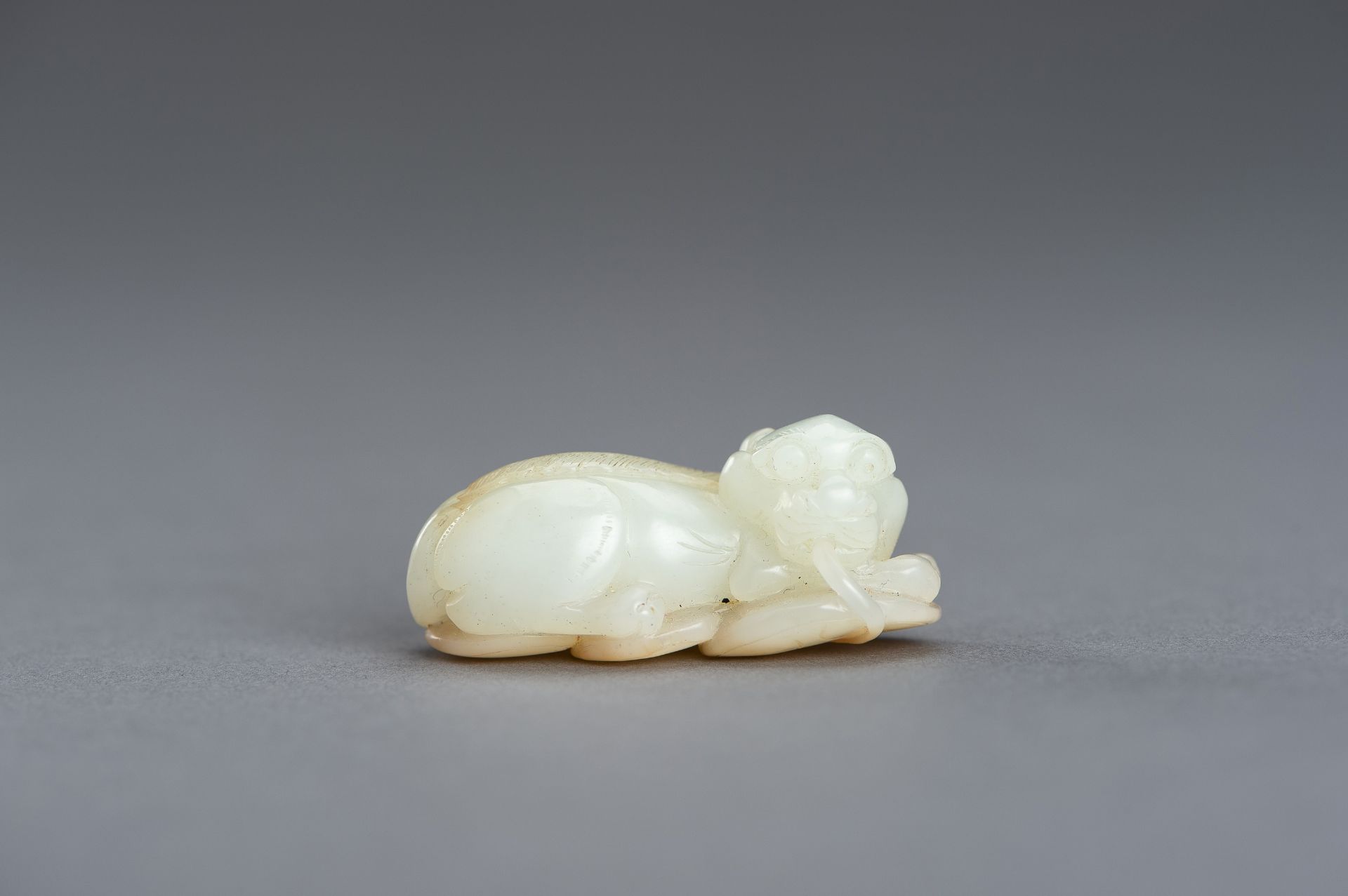 A WHITE AND RUSSET JADE PENDANT OF A BUDDHIST LION, QING DYNASTY - Image 3 of 12