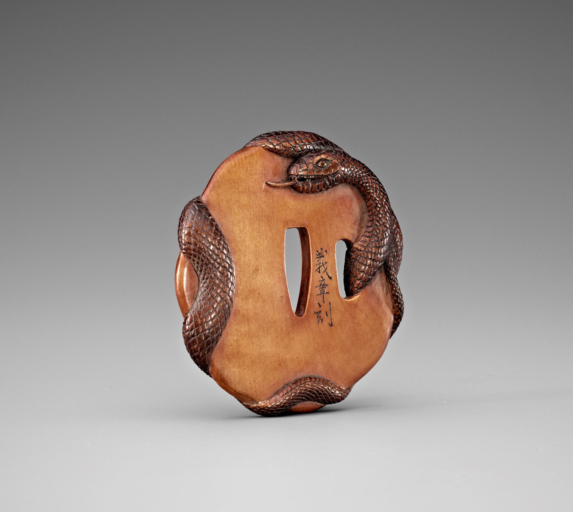 YOSHIAKI: A RARE WOOD TSUBA DEPICTING A SNAKE