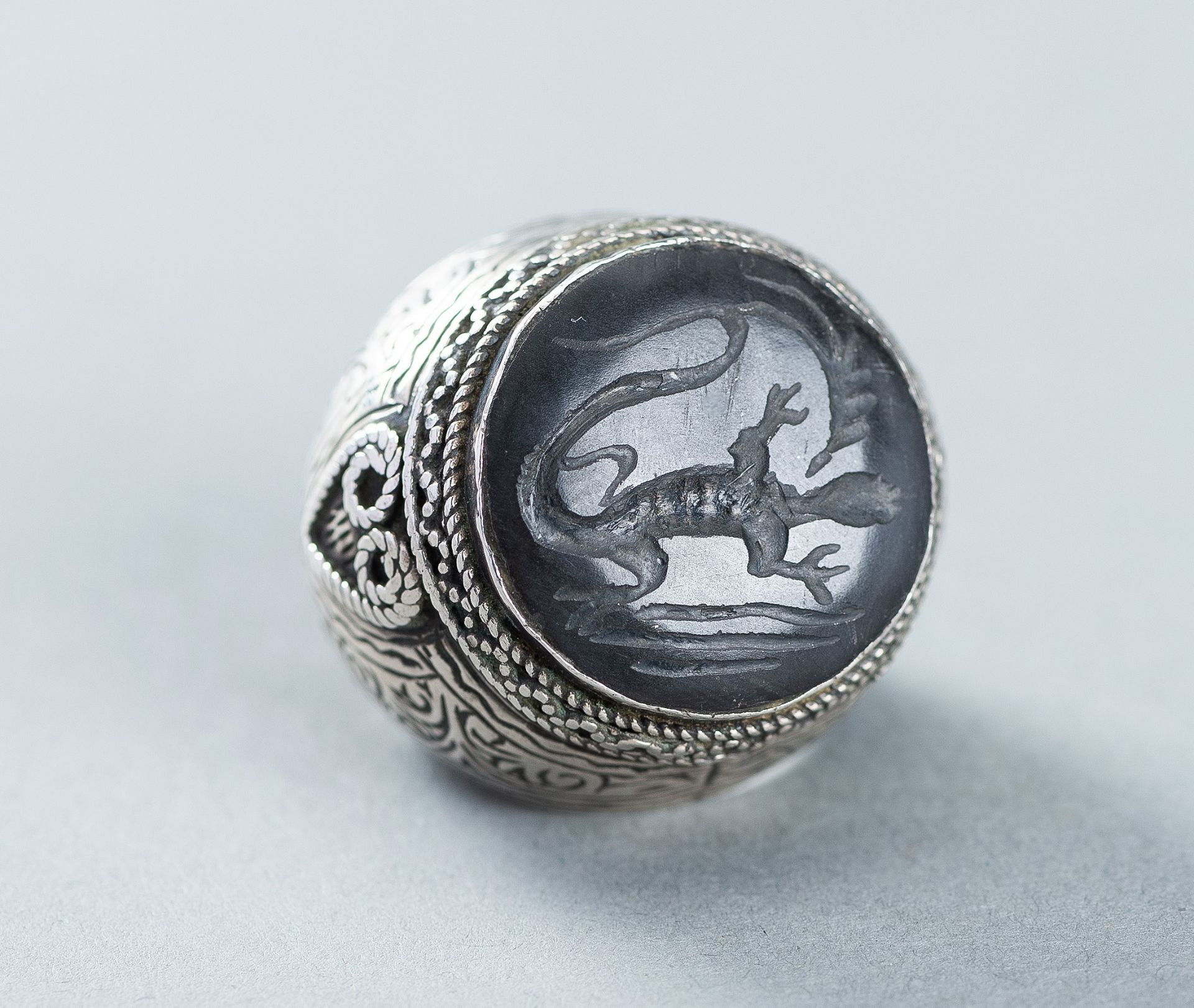 AN AGATE INTAGLIO INSET PERSIAN SILVER RING