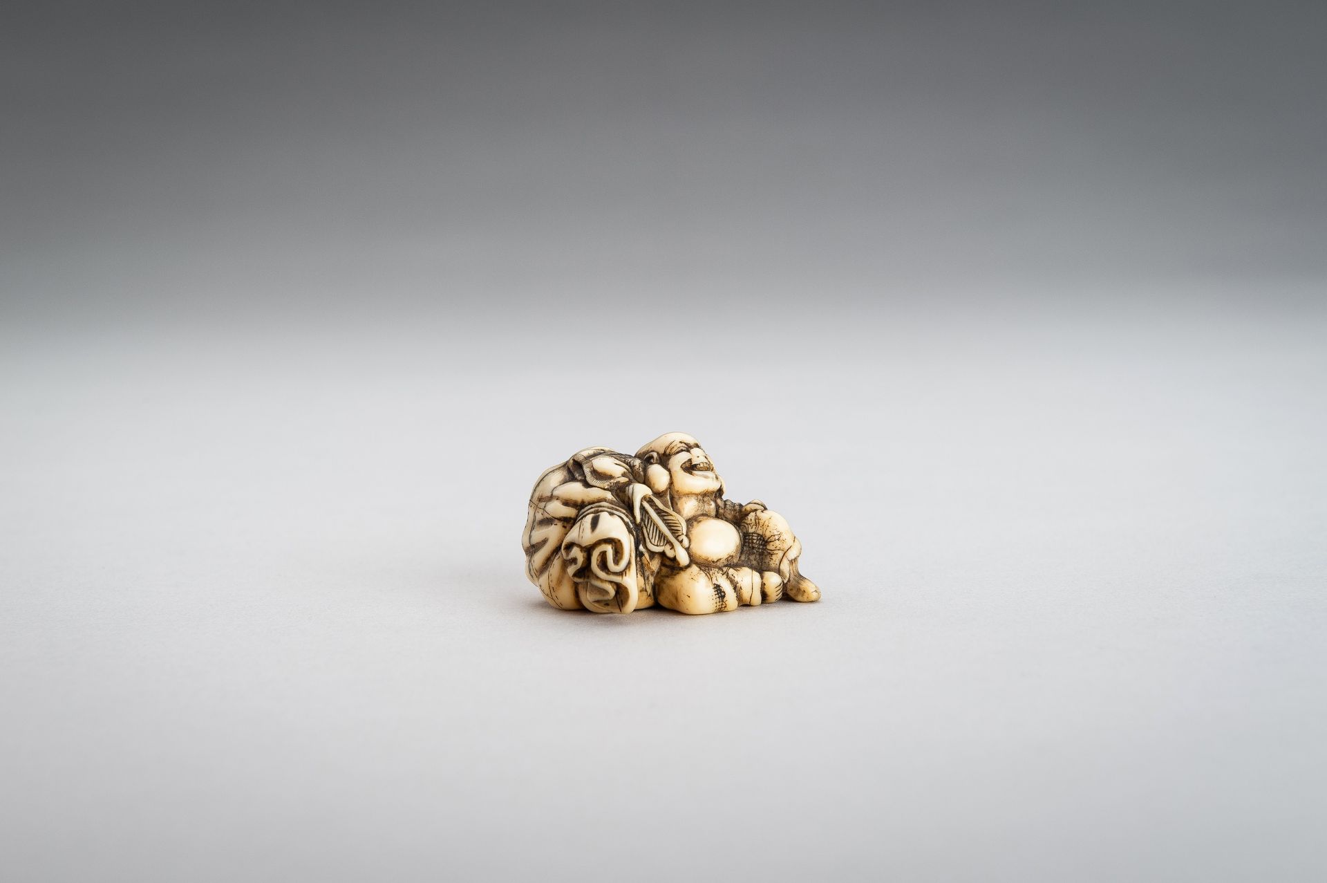 AN IVORY NETSUKE OF HOTEI WITH HIS TREASURE BAG - Bild 2 aus 10