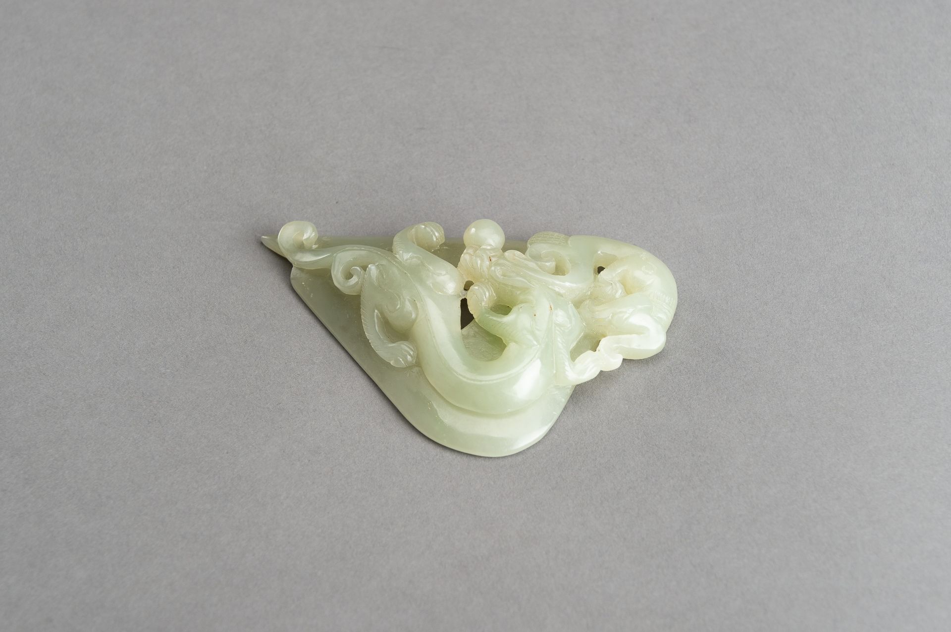 AN ARCHAISTIC PALE CELADON JADE PENDANT OF A CHILONG, 1920s - Image 8 of 14