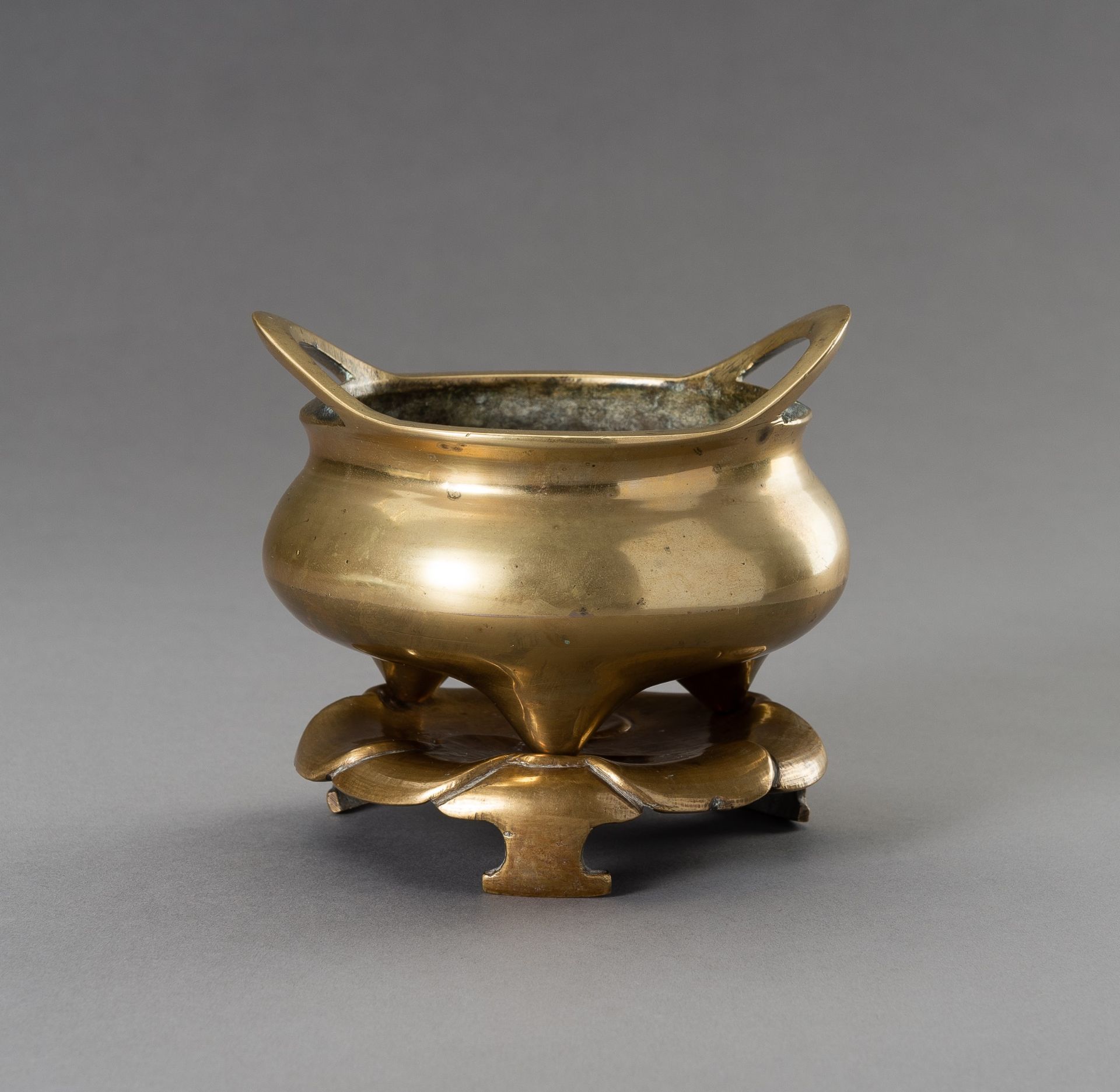 A GILT BRONZE TRIPOD CENSER WITH MATCHING STAND