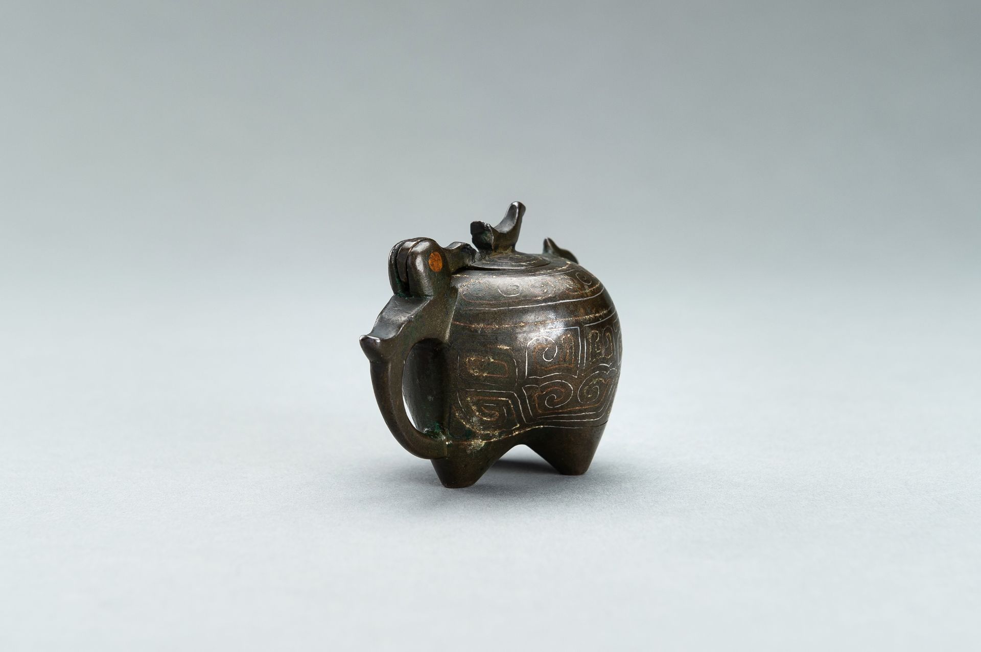 A SMALL COPPER AND SILVER INLAID BRONZE POURING TRIPOD VESSEL IN THE FORM OF AN ANIMAL, 17TH CENTURY - Bild 3 aus 11