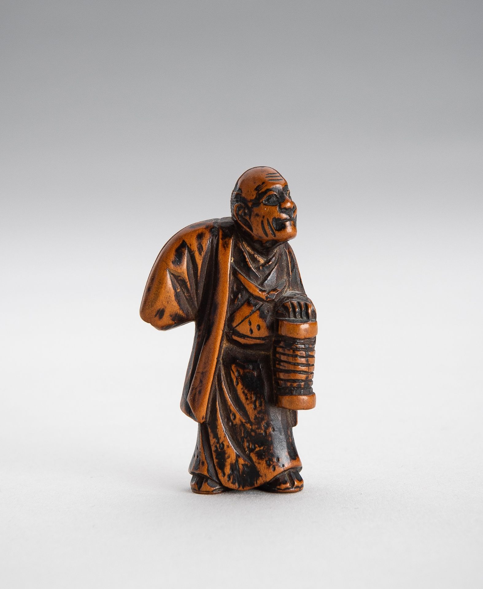 A BOXWOOD NETSUKE OF AN OLD MAN