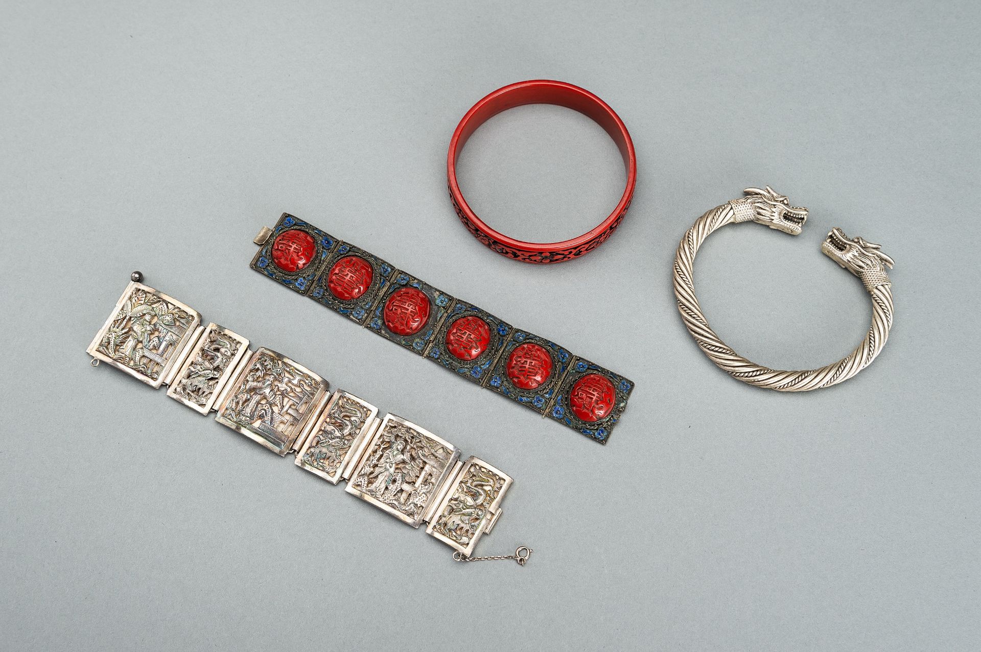 A GROUP OF FOUR METAL, SILVER-PLATED, AND CINNABAR LACQUER BRACELETS