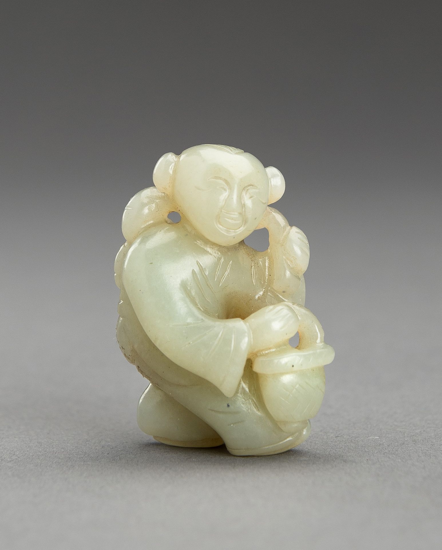 A SMALL PALE CELADON JADE FIGURE OF A BOY