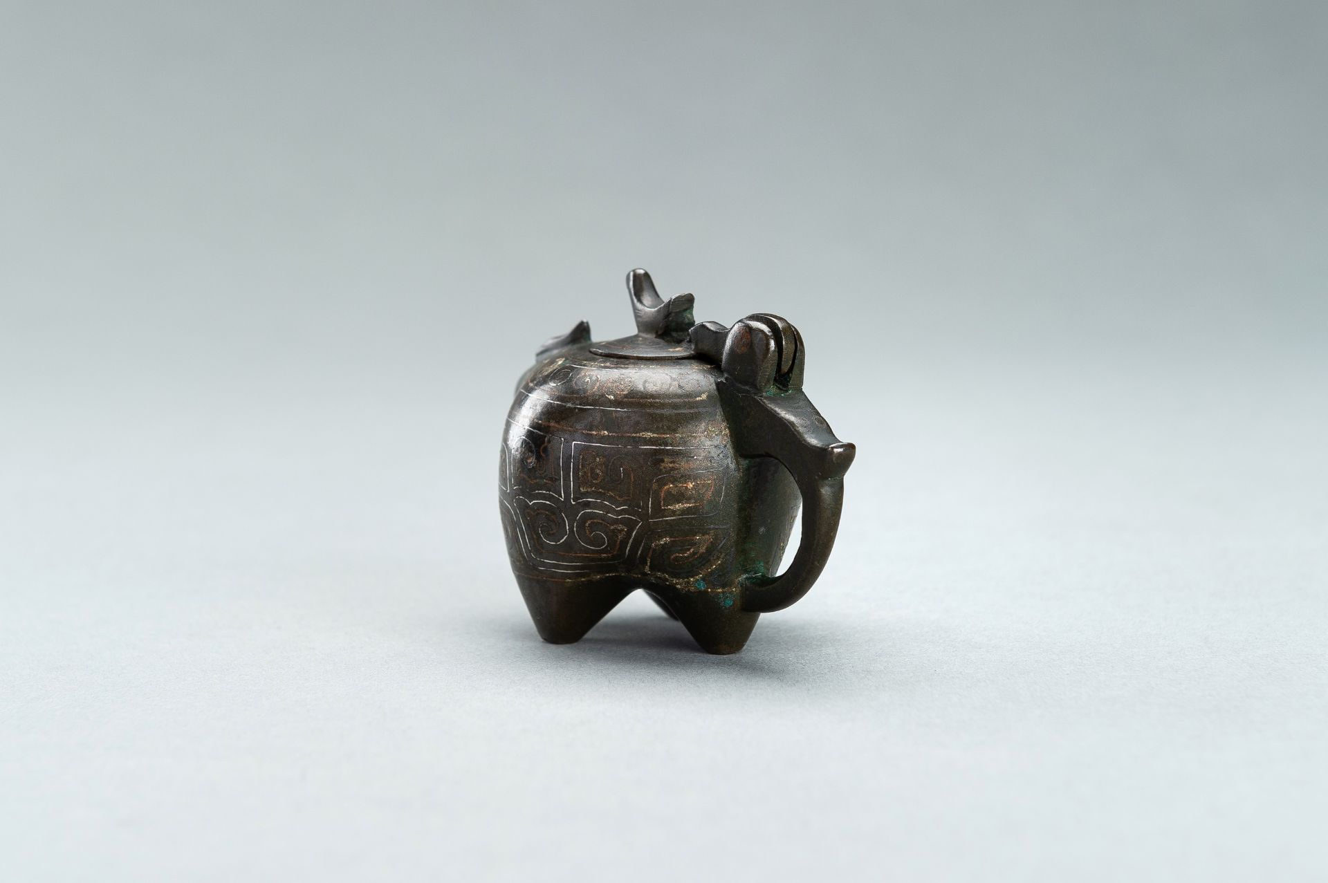 A SMALL COPPER AND SILVER INLAID BRONZE POURING TRIPOD VESSEL IN THE FORM OF AN ANIMAL, 17TH CENTURY - Bild 7 aus 11