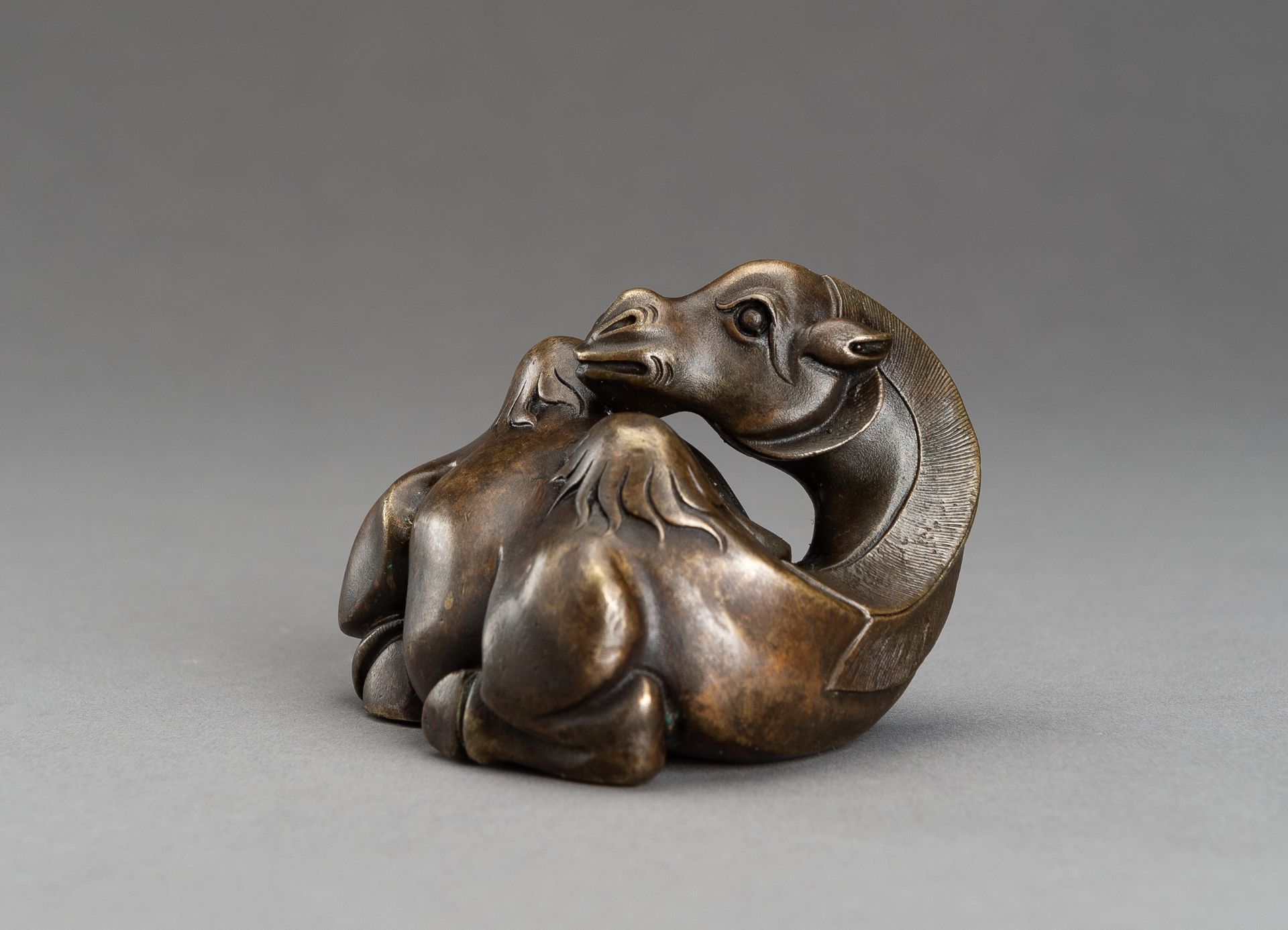 A BRONZE SCROLL WEIGHT OF A BACTRIAN CAMEL, QING