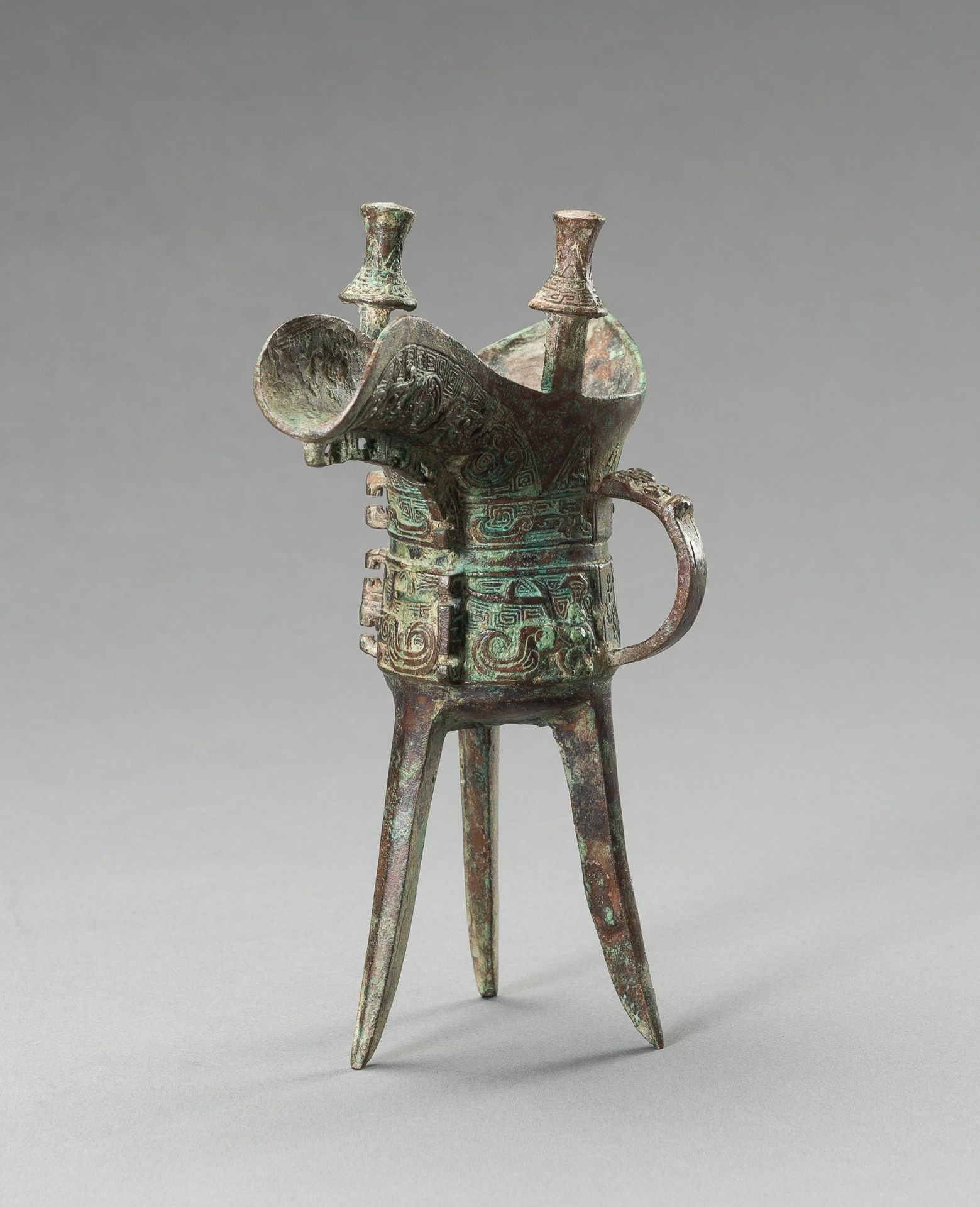 AN ARCHAISTIC SHANG-STYLE BRONZE RITUAL TRIPOD WINE VESSEL, JUE