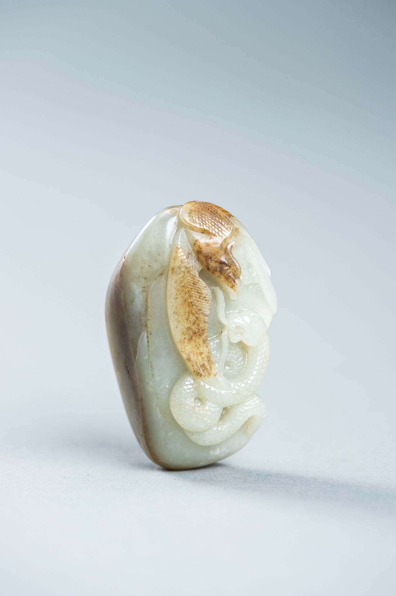 A CELADON AND RUSSET JADE 'EAGLE AND SNAKE' PENDANT, c. 1920s - Image 3 of 9