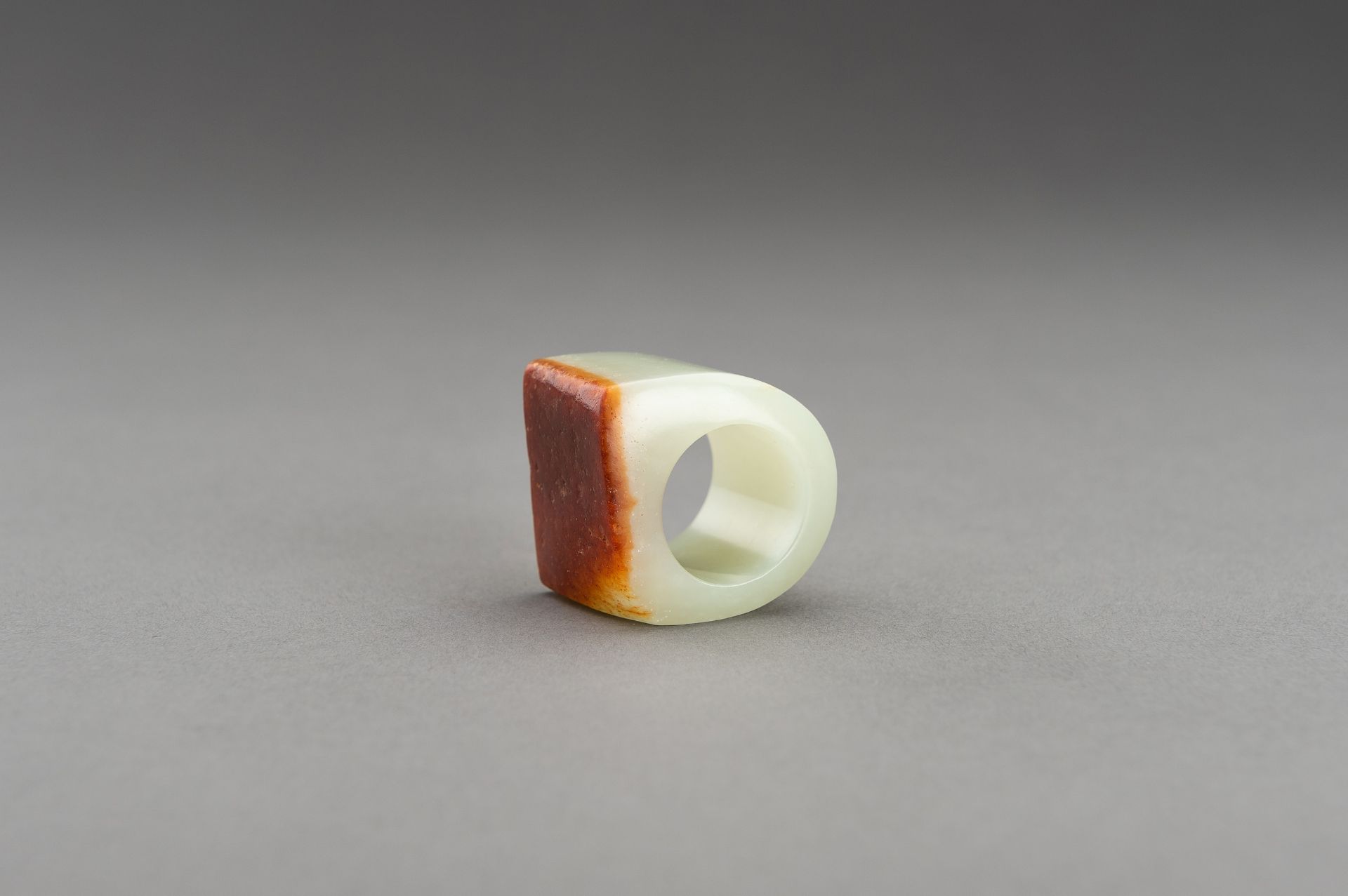 A PALE CELADON AND RUSSET JADE ARCHER'S RING - Image 4 of 8