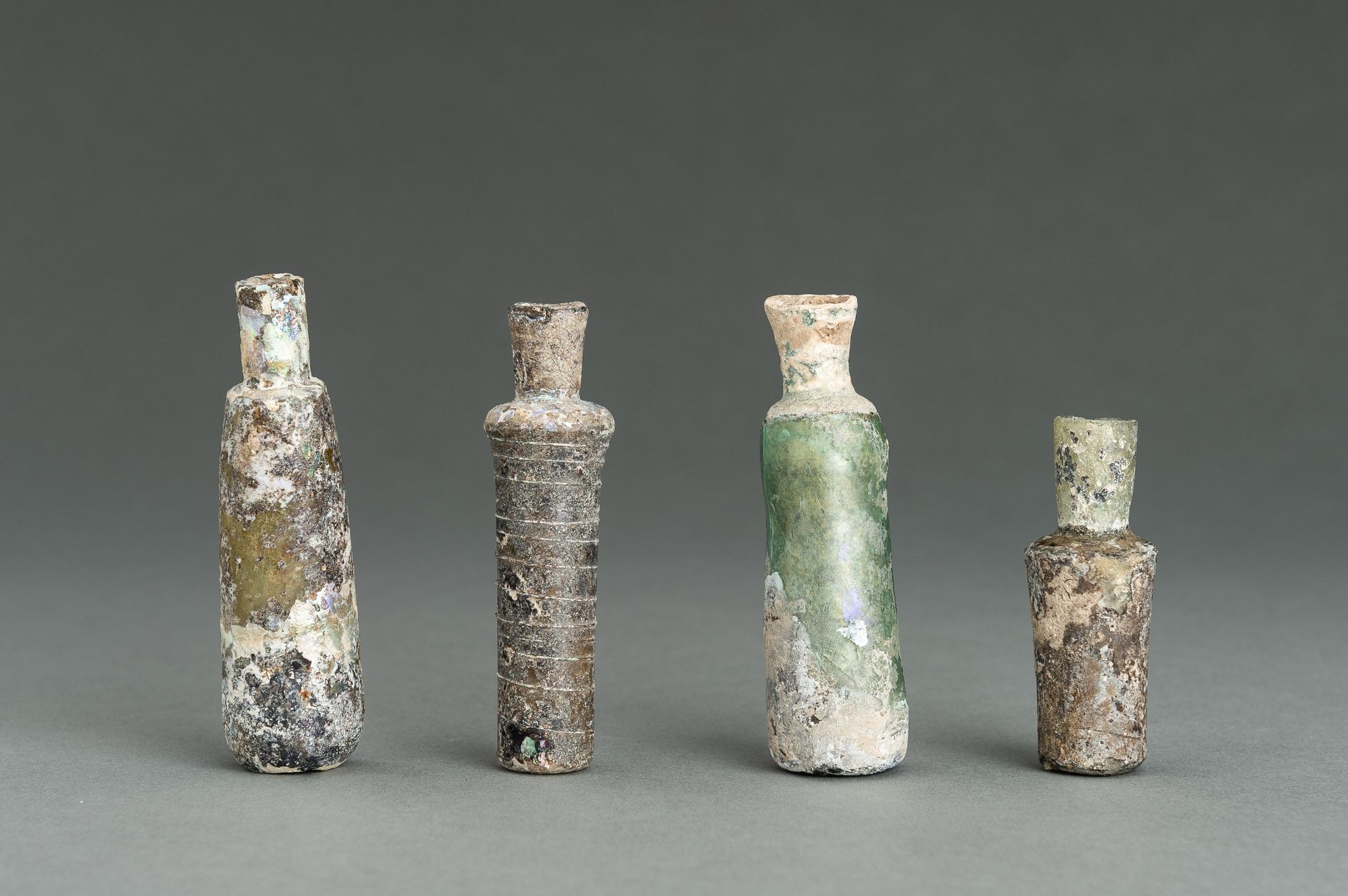 A GROUP OF FOUR FINE ROMAN MINIATURE GLASS BOTTLES