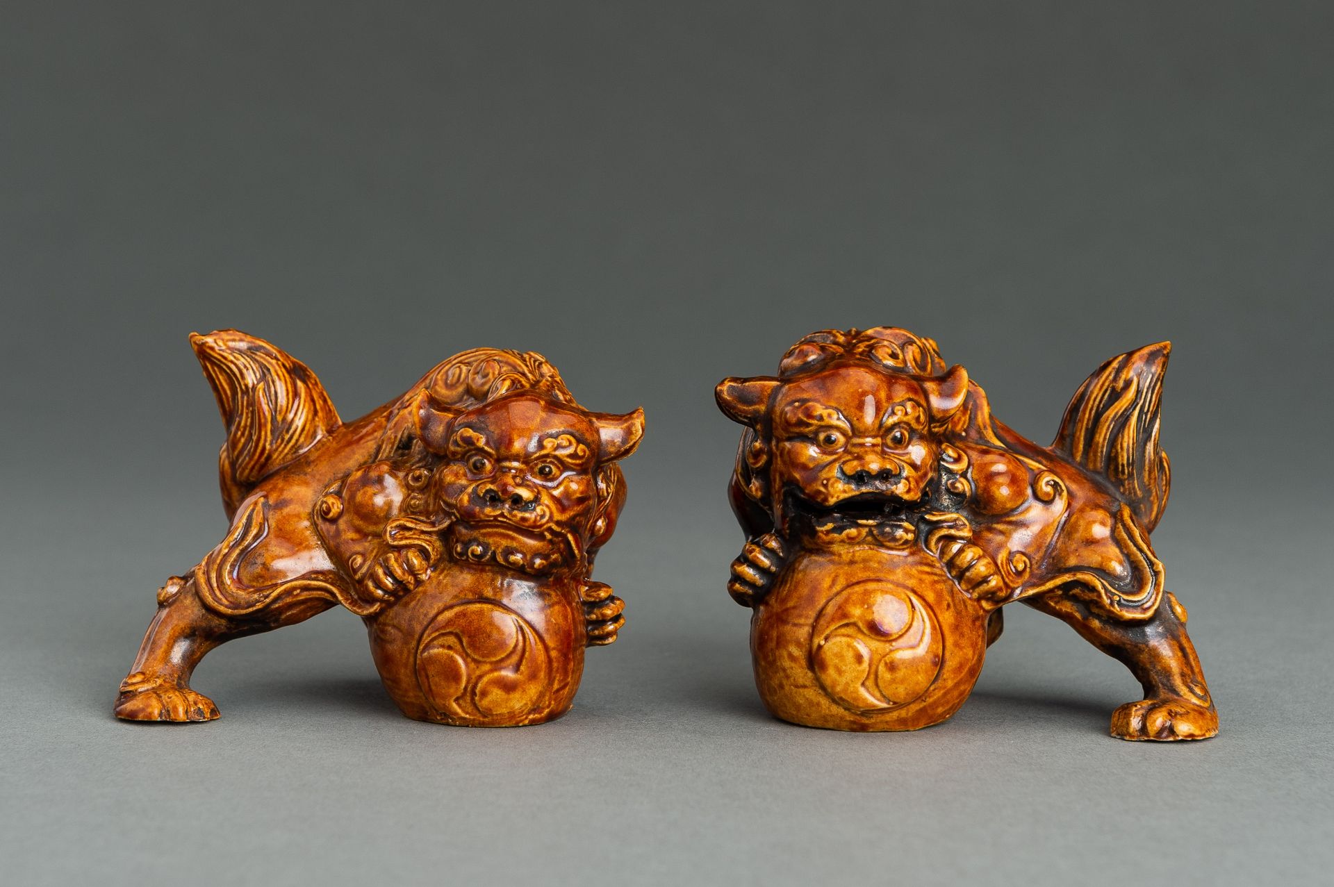 A PAIR OF AMBER GLAZED PORCELAIN SHISHI LIONS, MEIJI