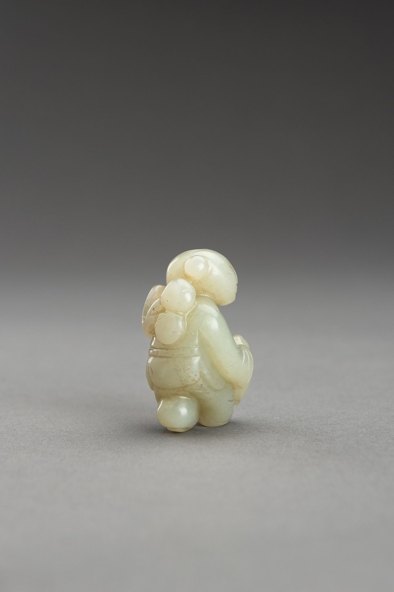 A SMALL PALE CELADON JADE FIGURE OF A BOY - Bild 6 aus 9