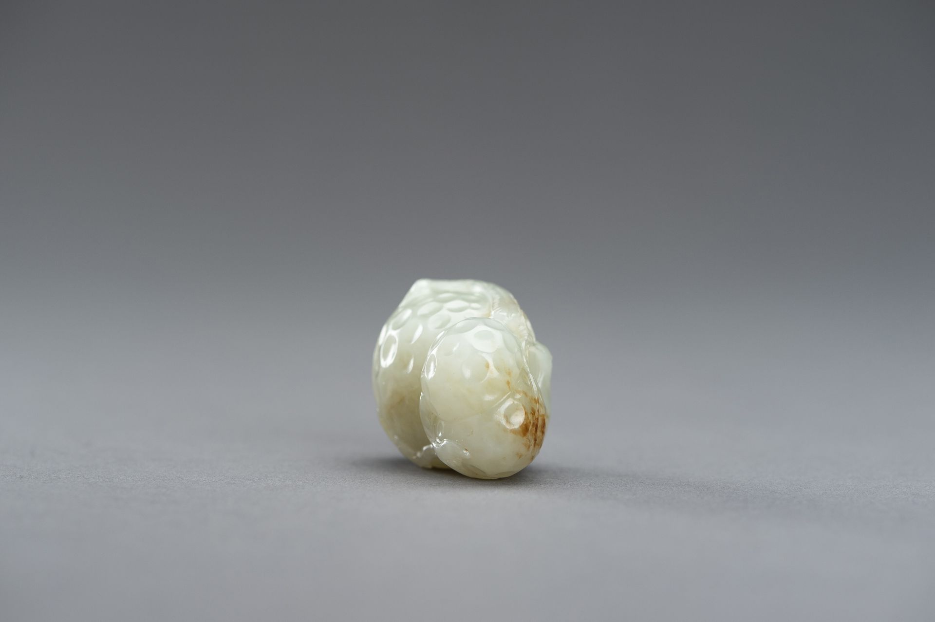 A CELADON JADE PENDANT OF A LYCHEE WITH BIRDS, 1920s - Image 5 of 9