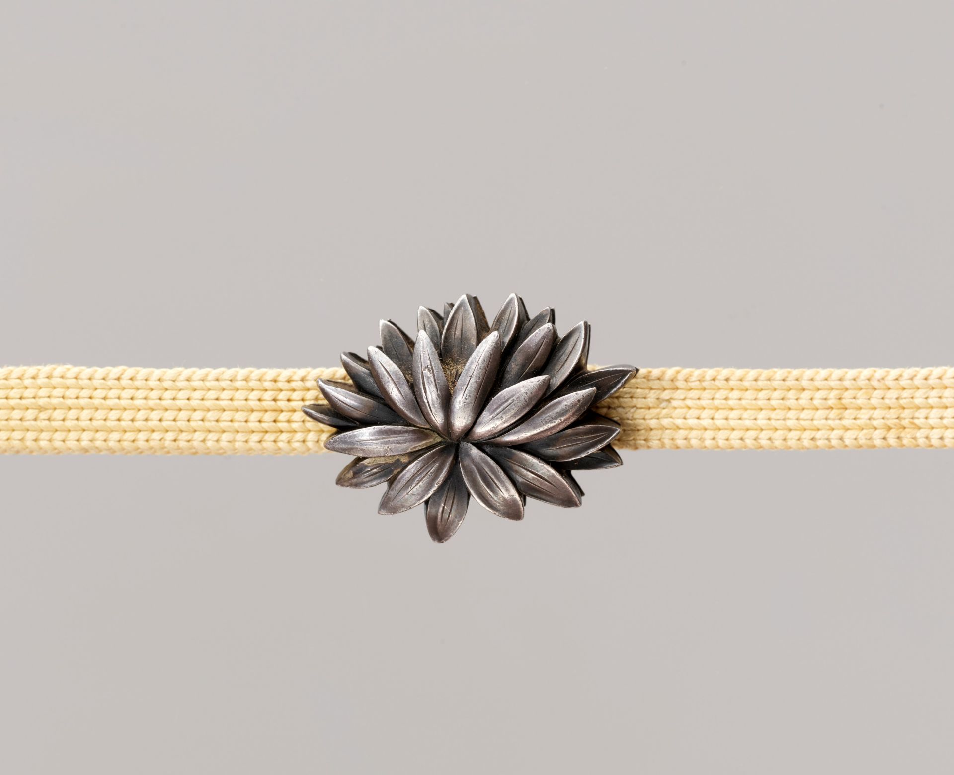 TOSHIMASA: A FINE SHIBUICHI OBIDOME (SASH CLIP) WITH CHRYSANTHEMUM FLOWER HEAD