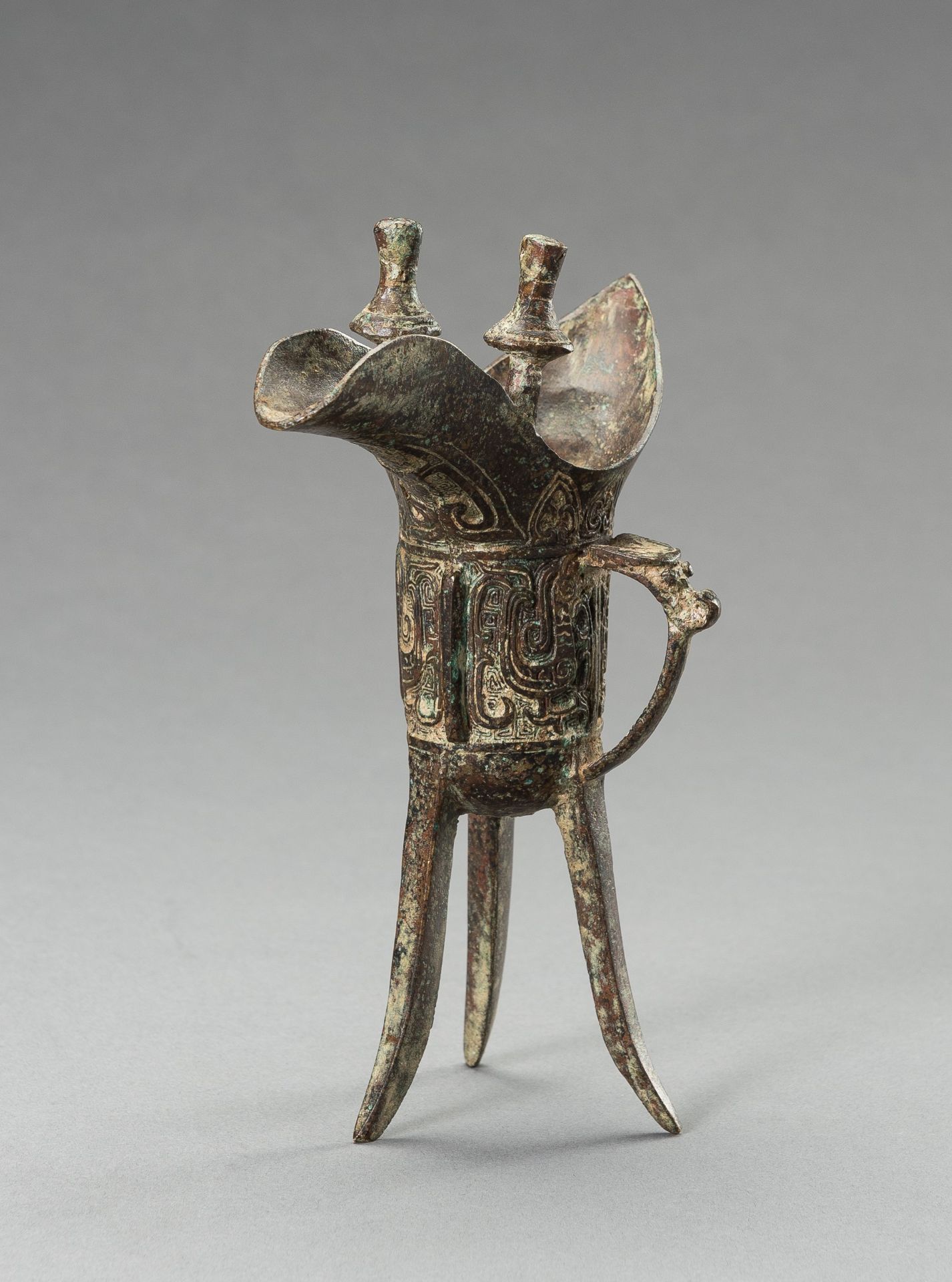 AN ARCHAISTIC SHANG-STYLE BRONZE RITUAL TRIPOD WINE VESSEL, JUE