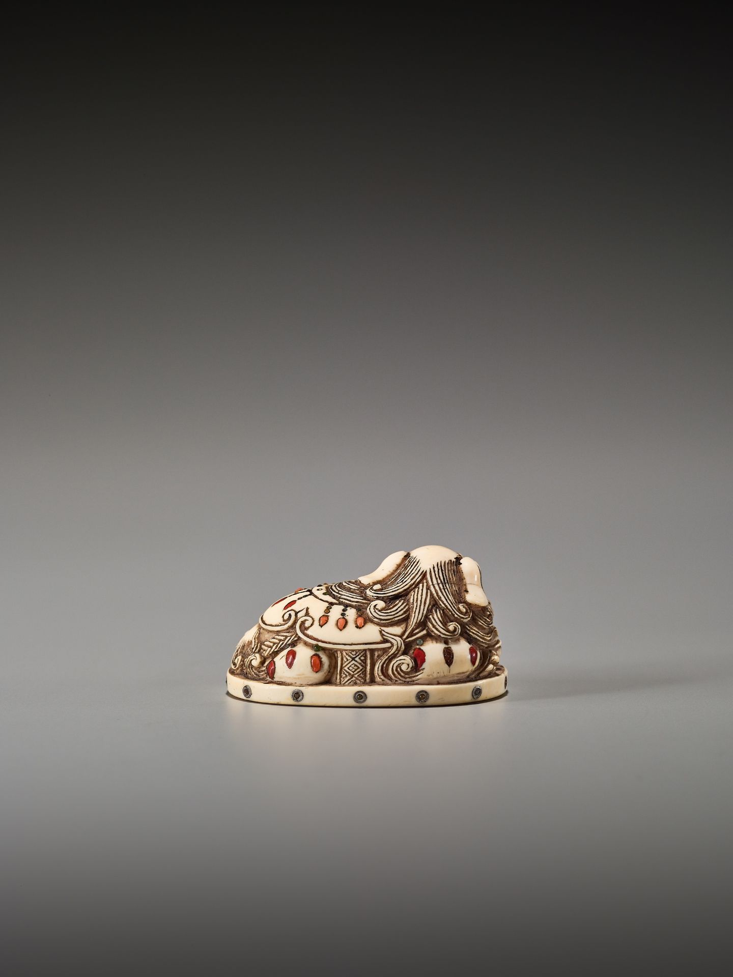 AN INLAID IVORY NETSUKE OF A RECUMBENT SHIBAYAMA SHISHI - Bild 5 aus 8