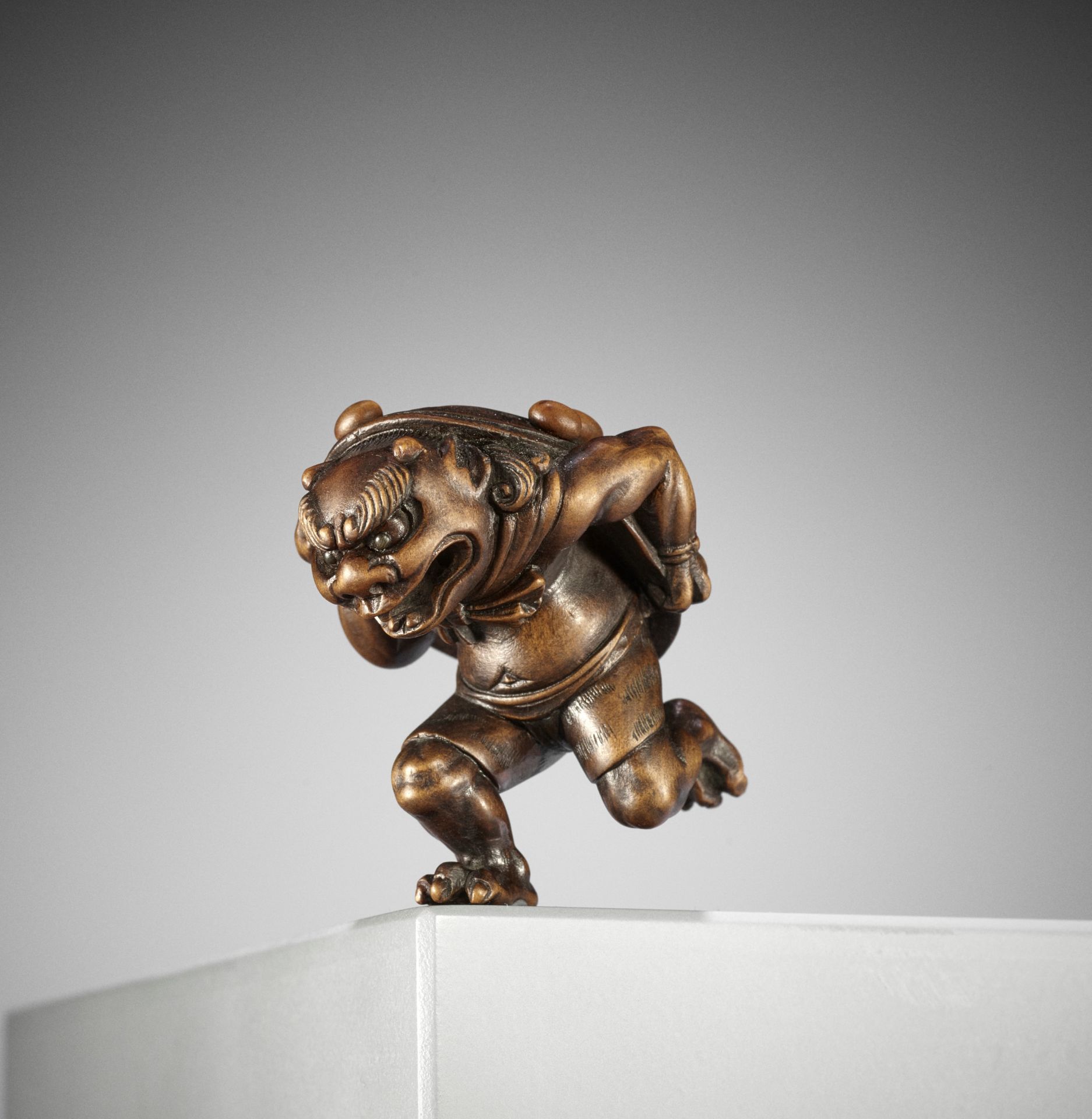 A FINE WOOD NETSUKE OF AN ONI AT SETSUBUN