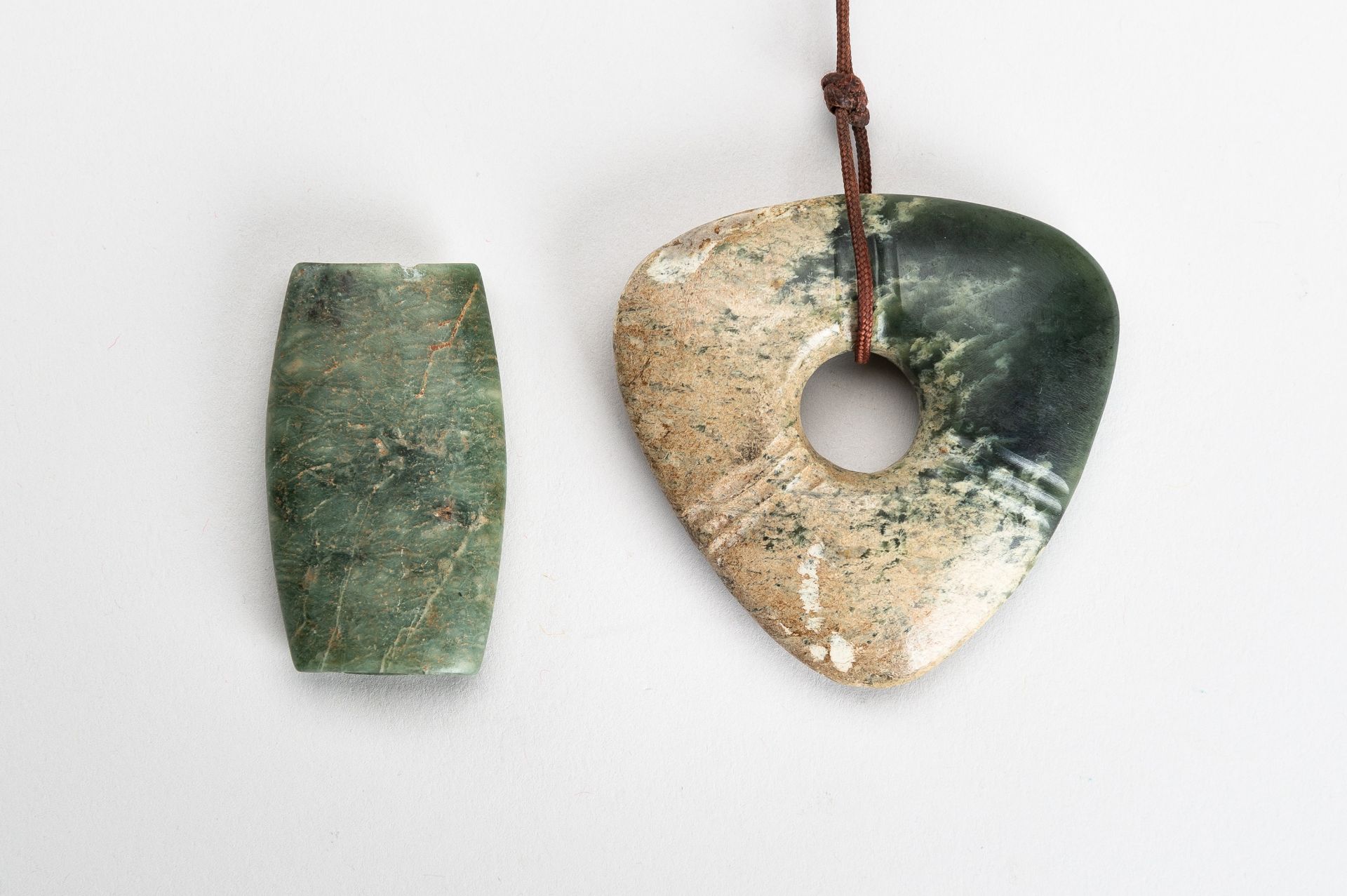 AN ARCHAISTIC LOT WITH A JADE AND A SERPENTINE PENDANT