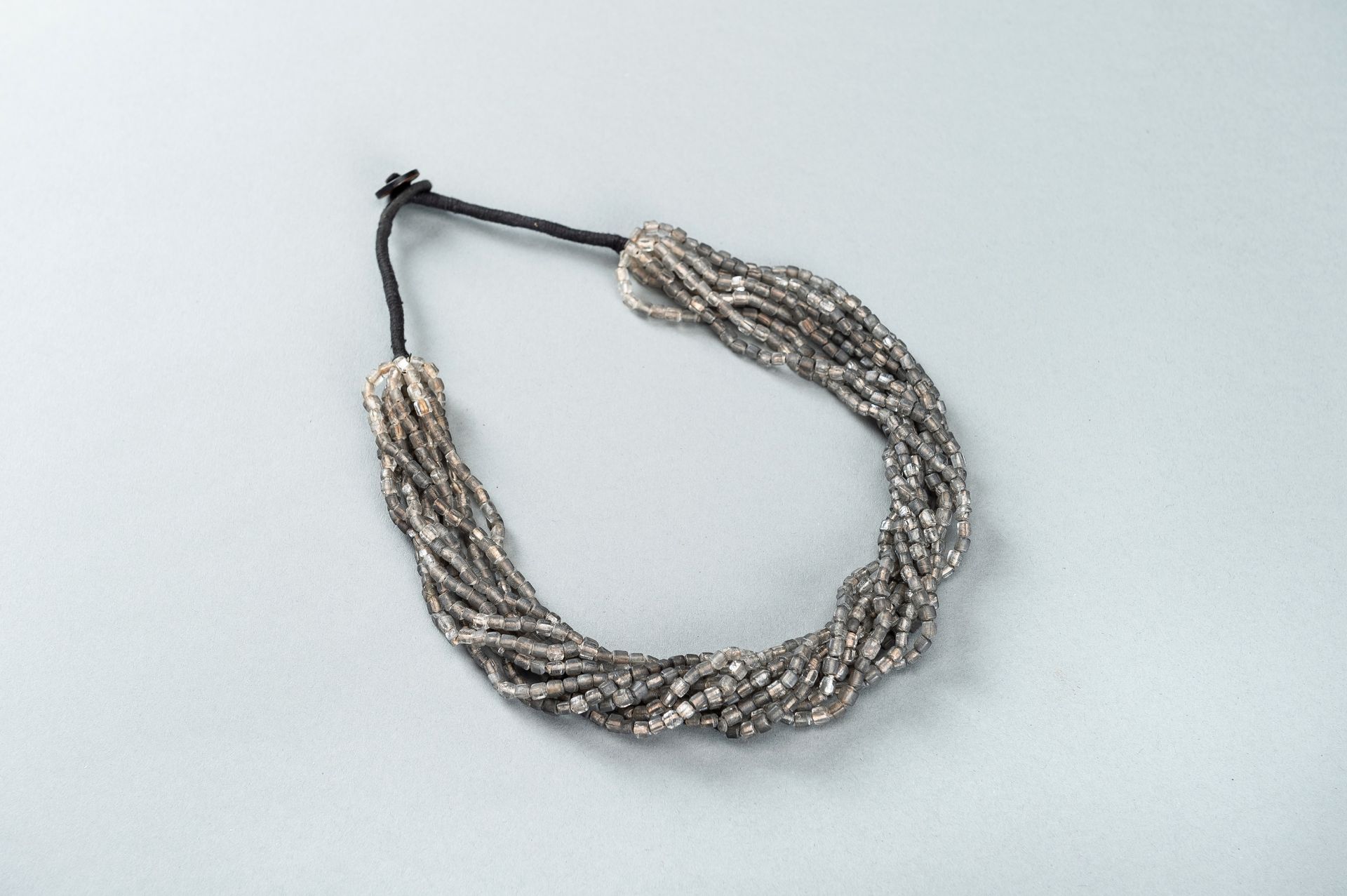 A WESTERN ASIATIC GRAY GLASS NECKLACE