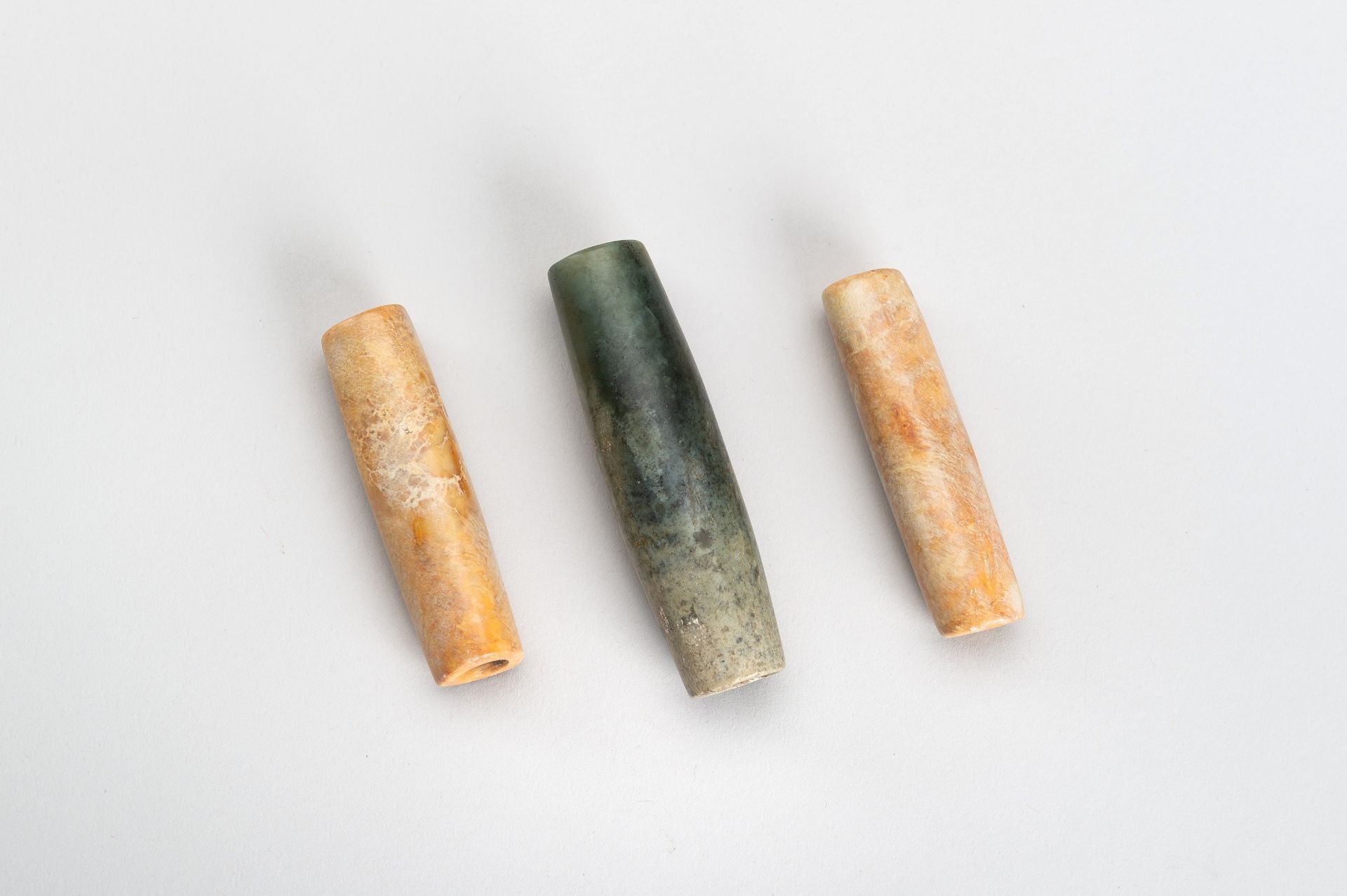 A GROUP OF THREE AGATE AND JADE BEADS