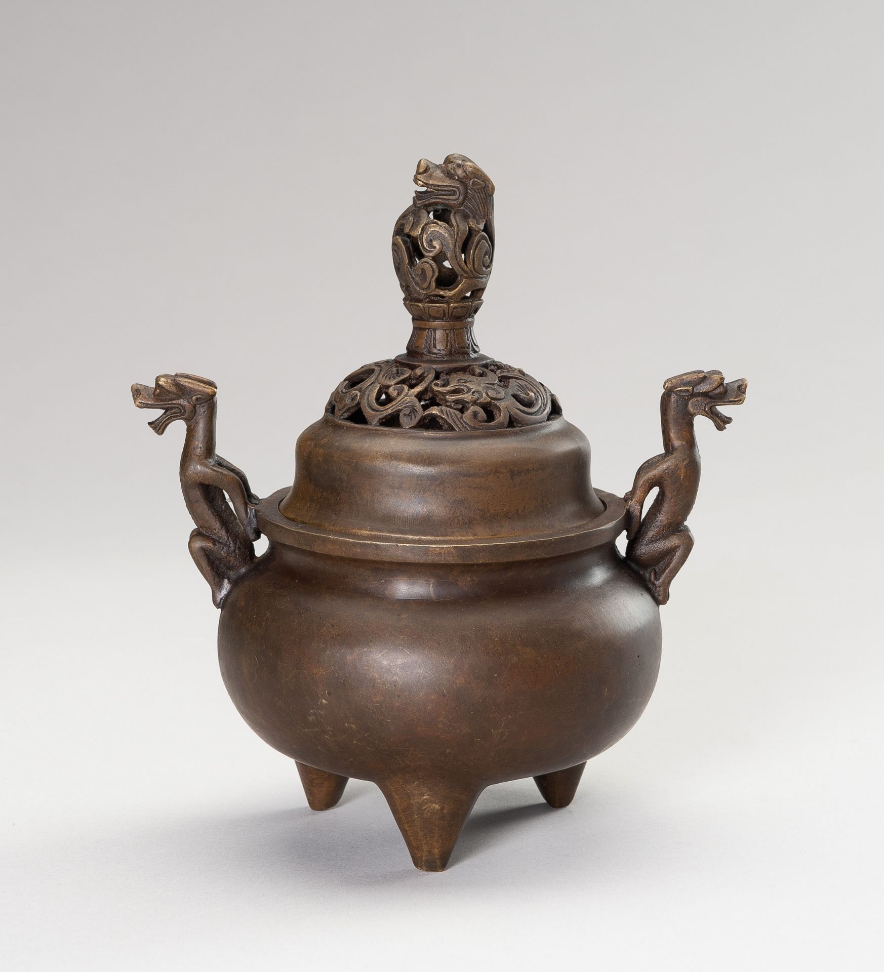 A BRONZE TRIPOD CENSER WITH DRAGONS