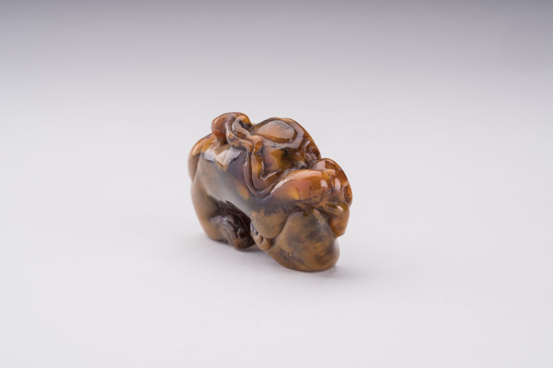 A RARE AMBER CARVING OF A BUDDHIST LION WITH BALL - Bild 2 aus 6