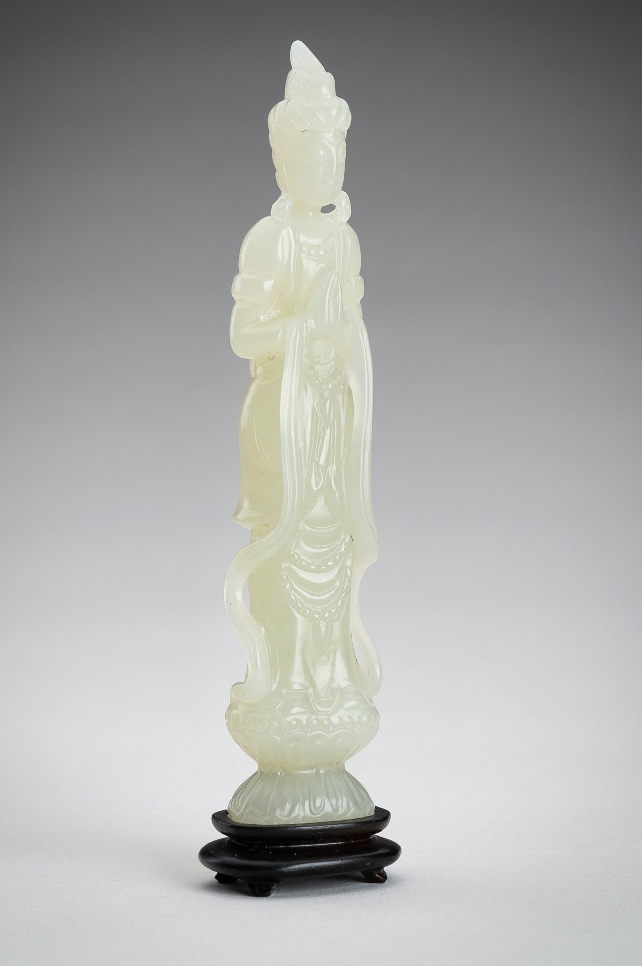 A PALE CELADON JADE CARVING OF A GUANYIN, 1900s