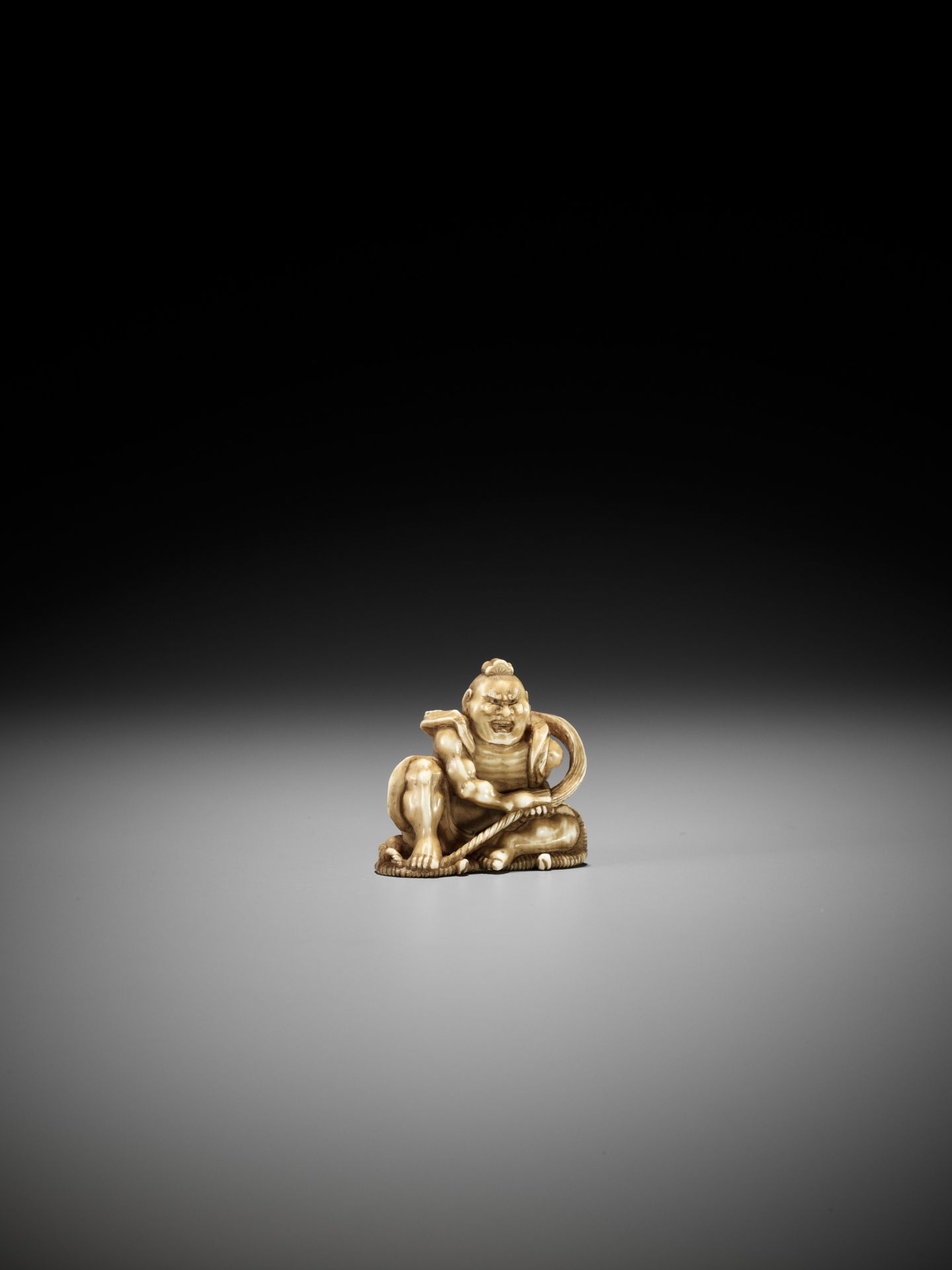 TOMOMASA: AN IVORY NETSUKE OF NIO BRAIDING A SANDAL - Bild 2 aus 11