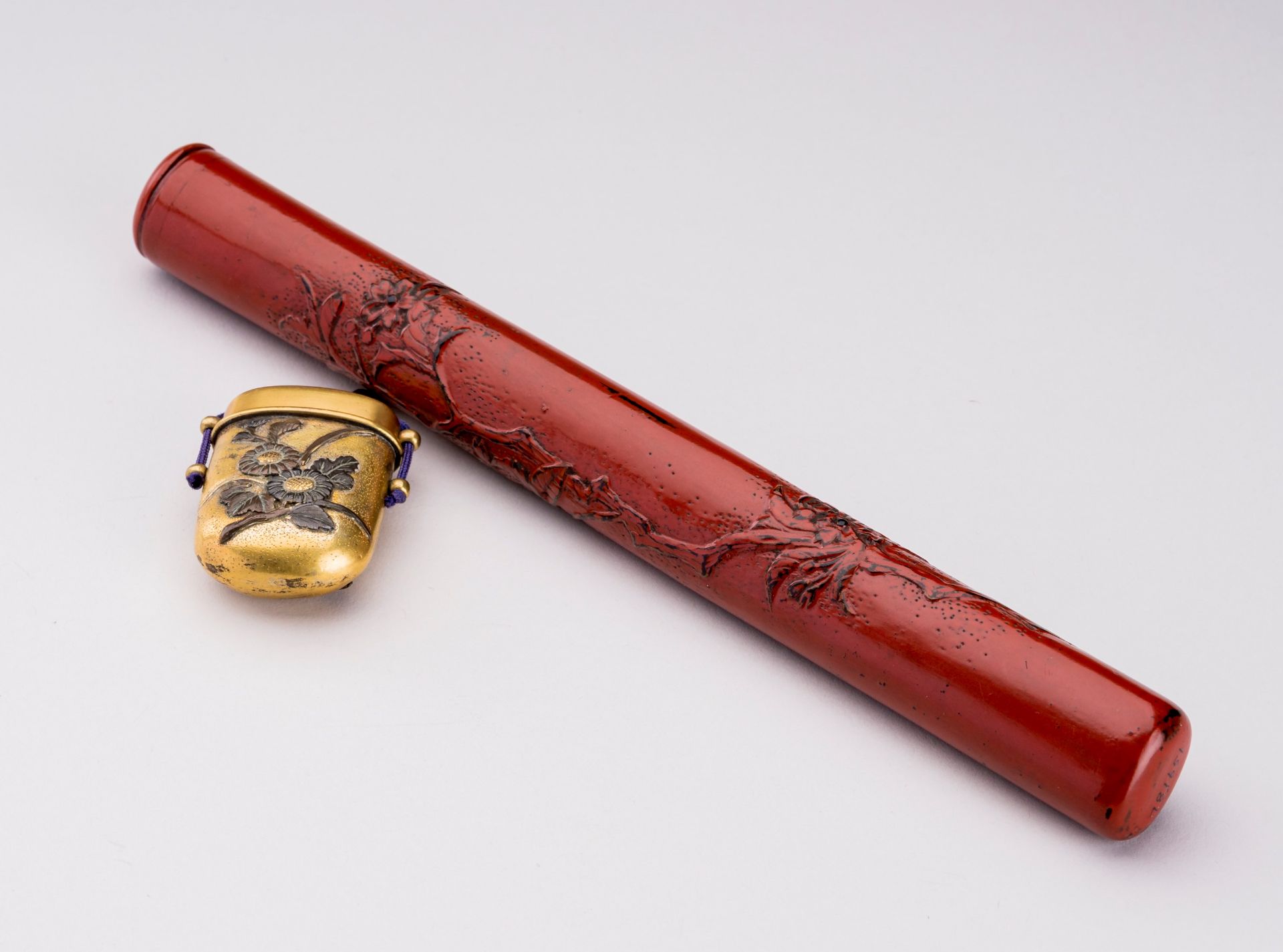 A CINNABAR LACQUERED WOOD AND BRASS YATATE, MEIJI
