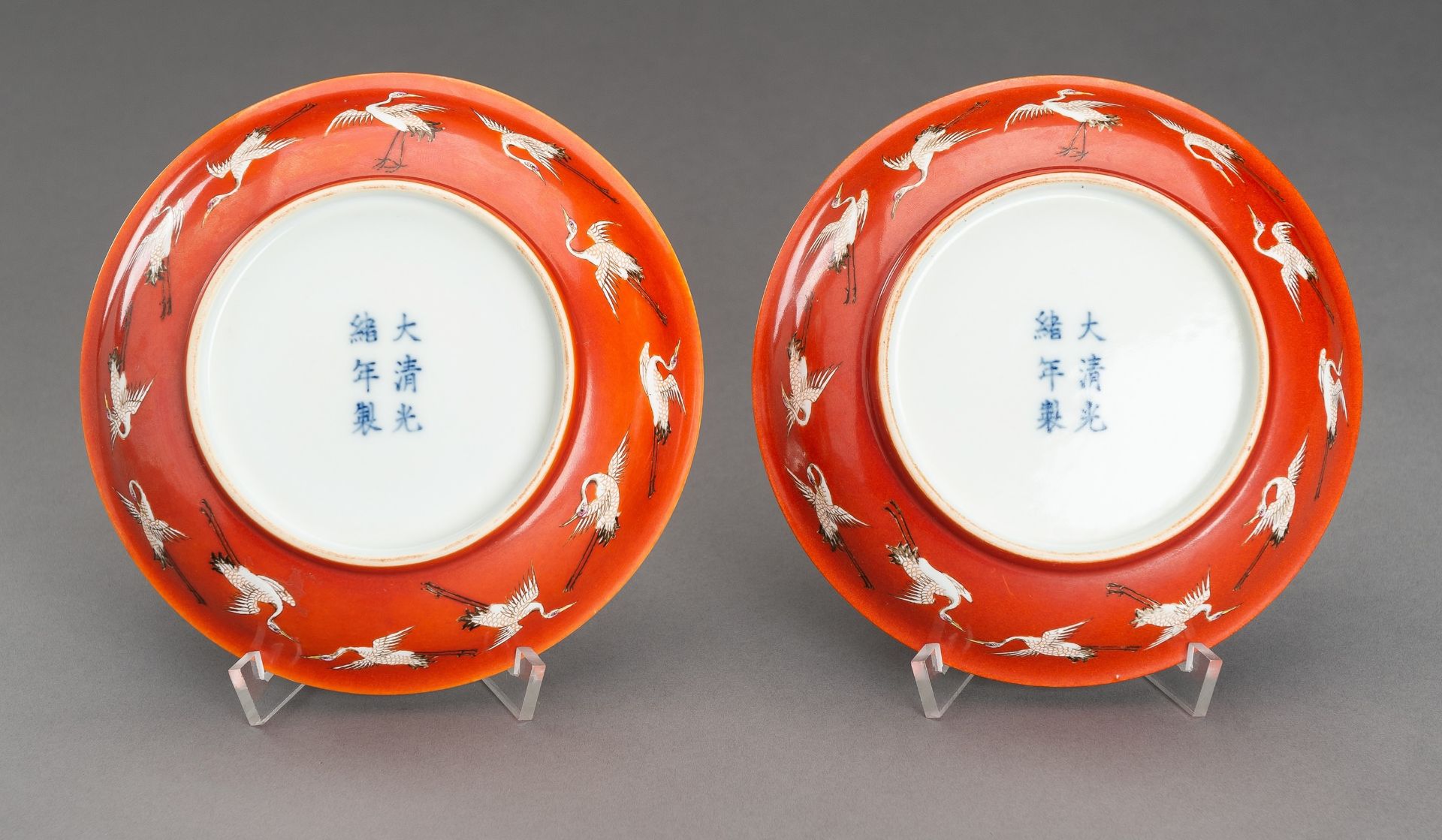 A PAIR OF RED GROUND 'BATS AND CRANES' SAUCER DISHES, GUANGXU MARK AND PROBABLY OF THE PERIOD