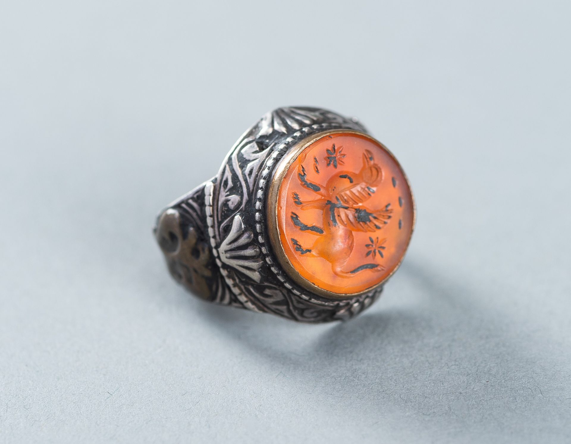 AN AGATE INTAGLIO INSET PERSIAN SILVER RING