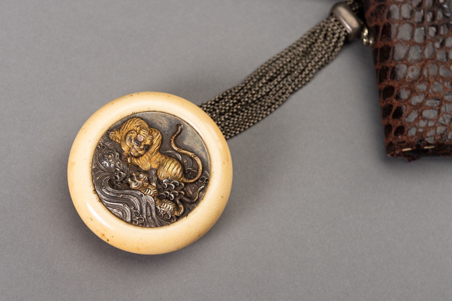 A LEATHER TABAKO-IRE AND ENSEMBLE WITH SILVER-FITTED KAGAMIBUTA NETSUKE DEPICTING A TIGER AND YOUNG - Bild 2 aus 9