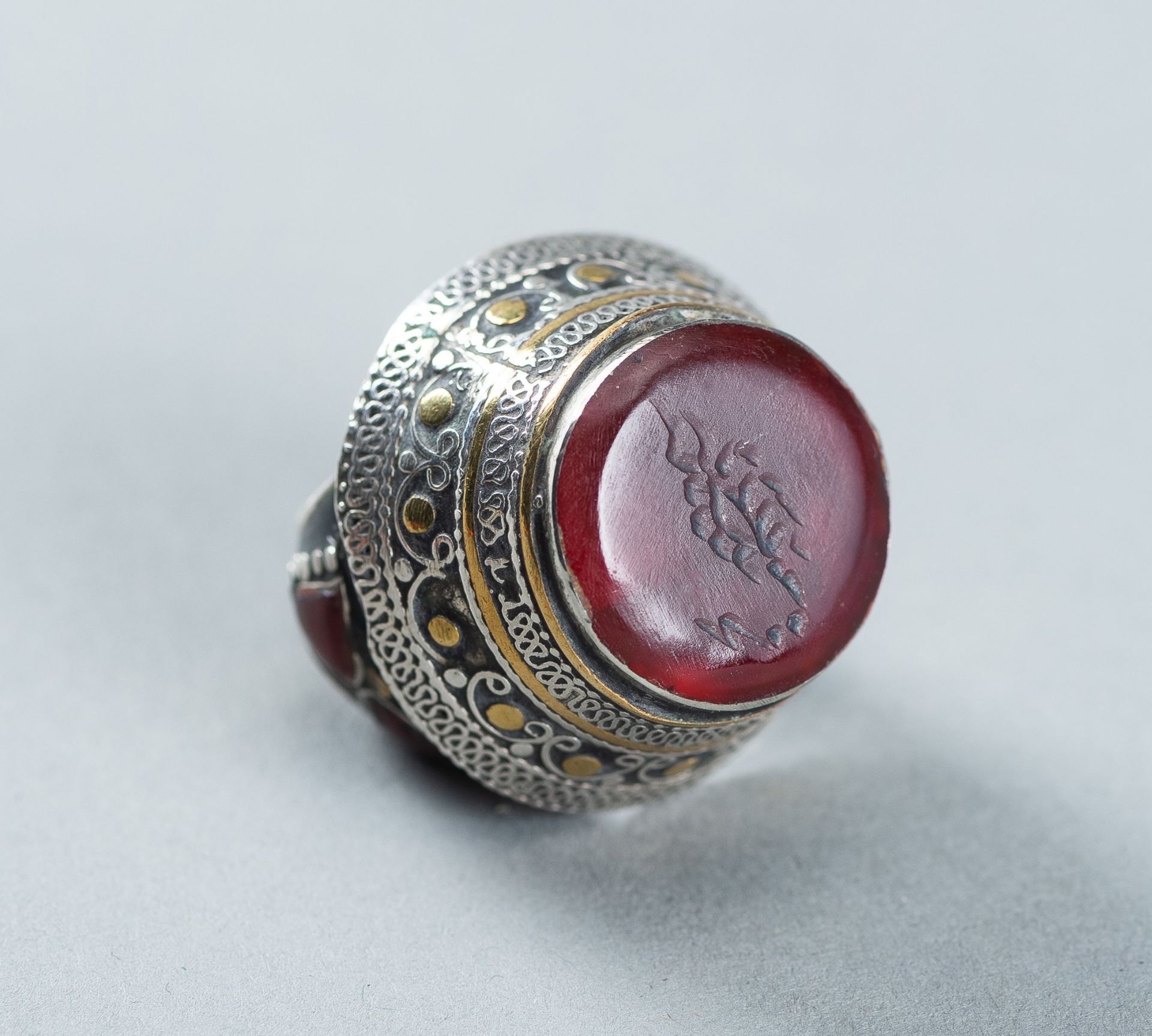 AN AGATE INTAGLIO INSET PERSIAN SILVER RING