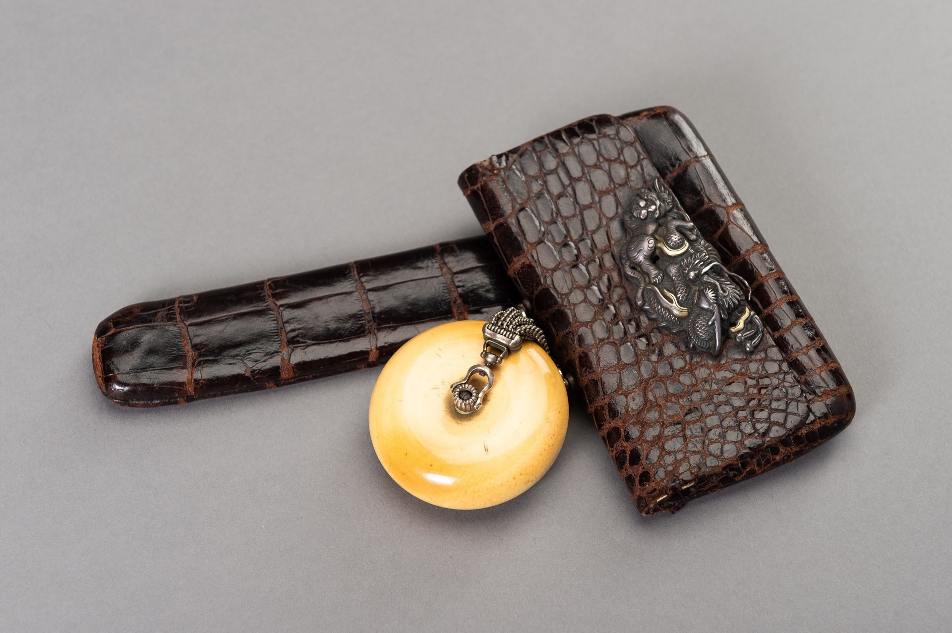 A LEATHER TABAKO-IRE AND ENSEMBLE WITH SILVER-FITTED KAGAMIBUTA NETSUKE DEPICTING A TIGER AND YOUNG - Bild 6 aus 9