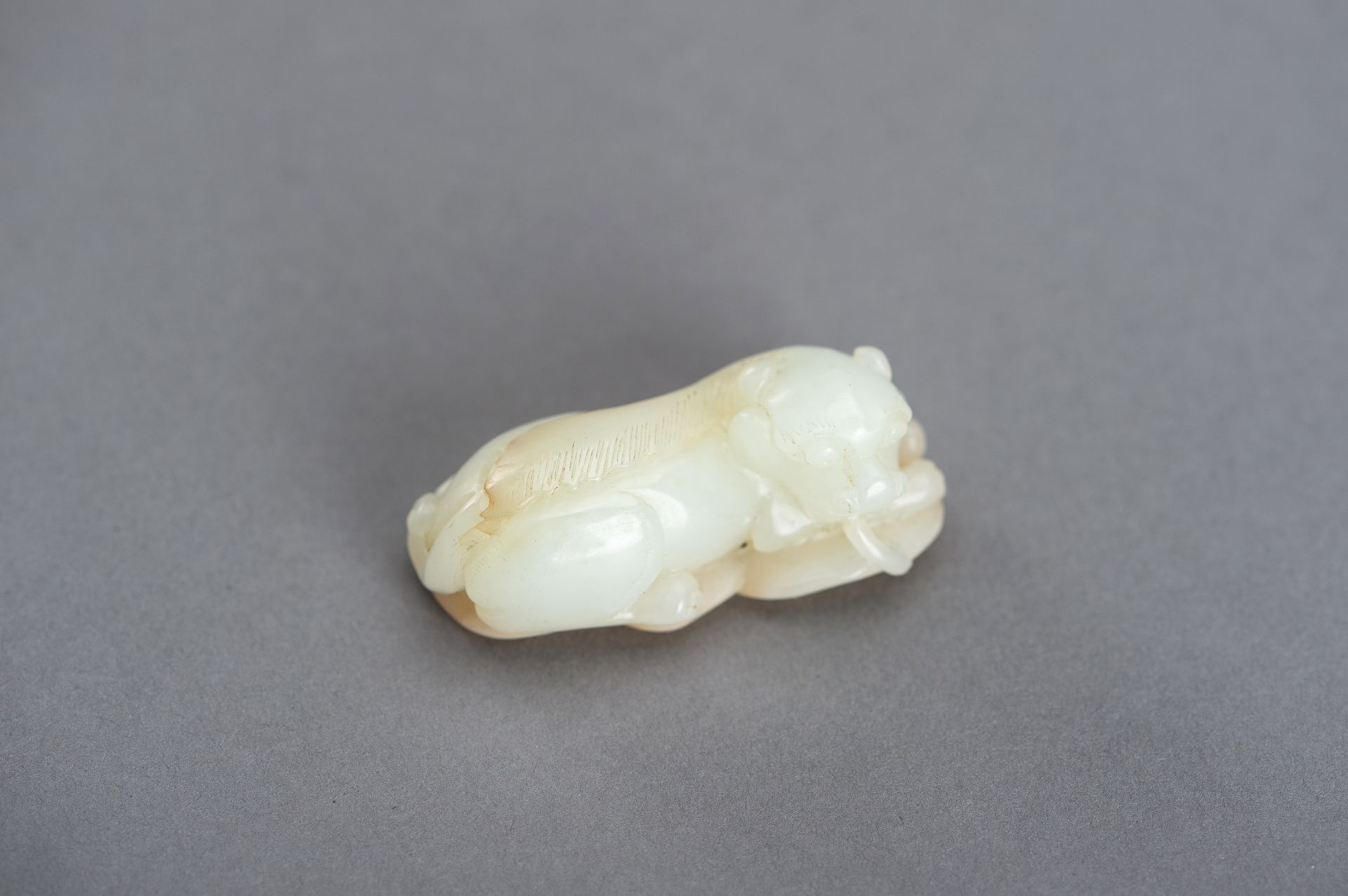 A WHITE AND RUSSET JADE PENDANT OF A BUDDHIST LION, QING DYNASTY - Image 10 of 12