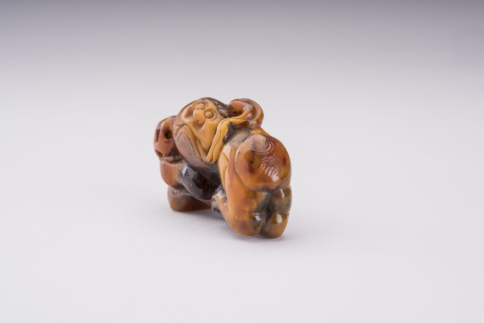 A RARE AMBER CARVING OF A BUDDHIST LION WITH BALL - Bild 4 aus 6