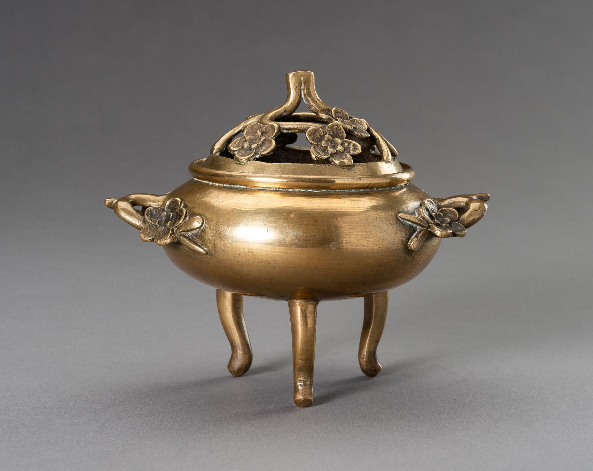 A `CHERRY BLOSSOMS' GILT BRONZE TRIPOD CENSER