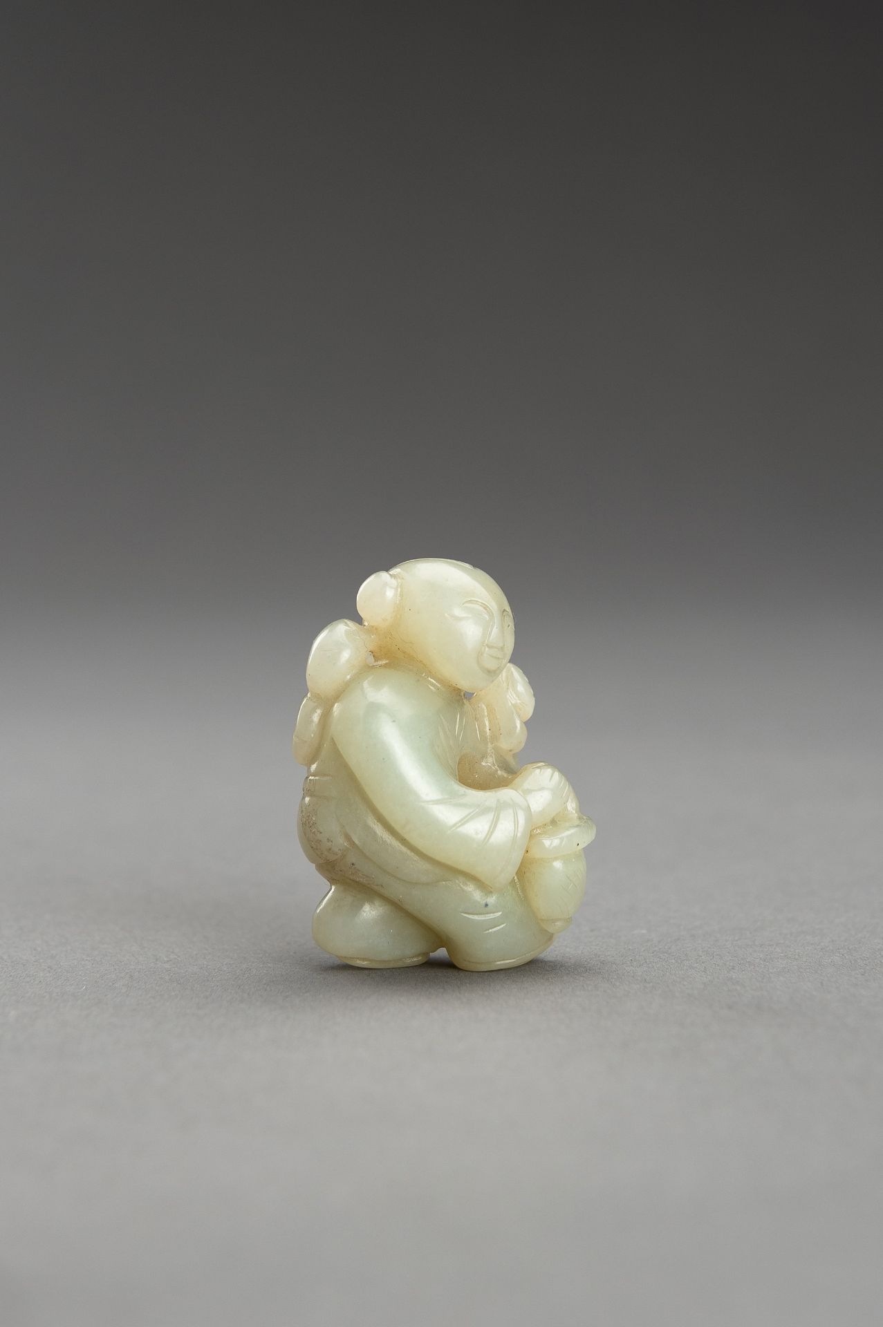 A SMALL PALE CELADON JADE FIGURE OF A BOY - Bild 5 aus 9