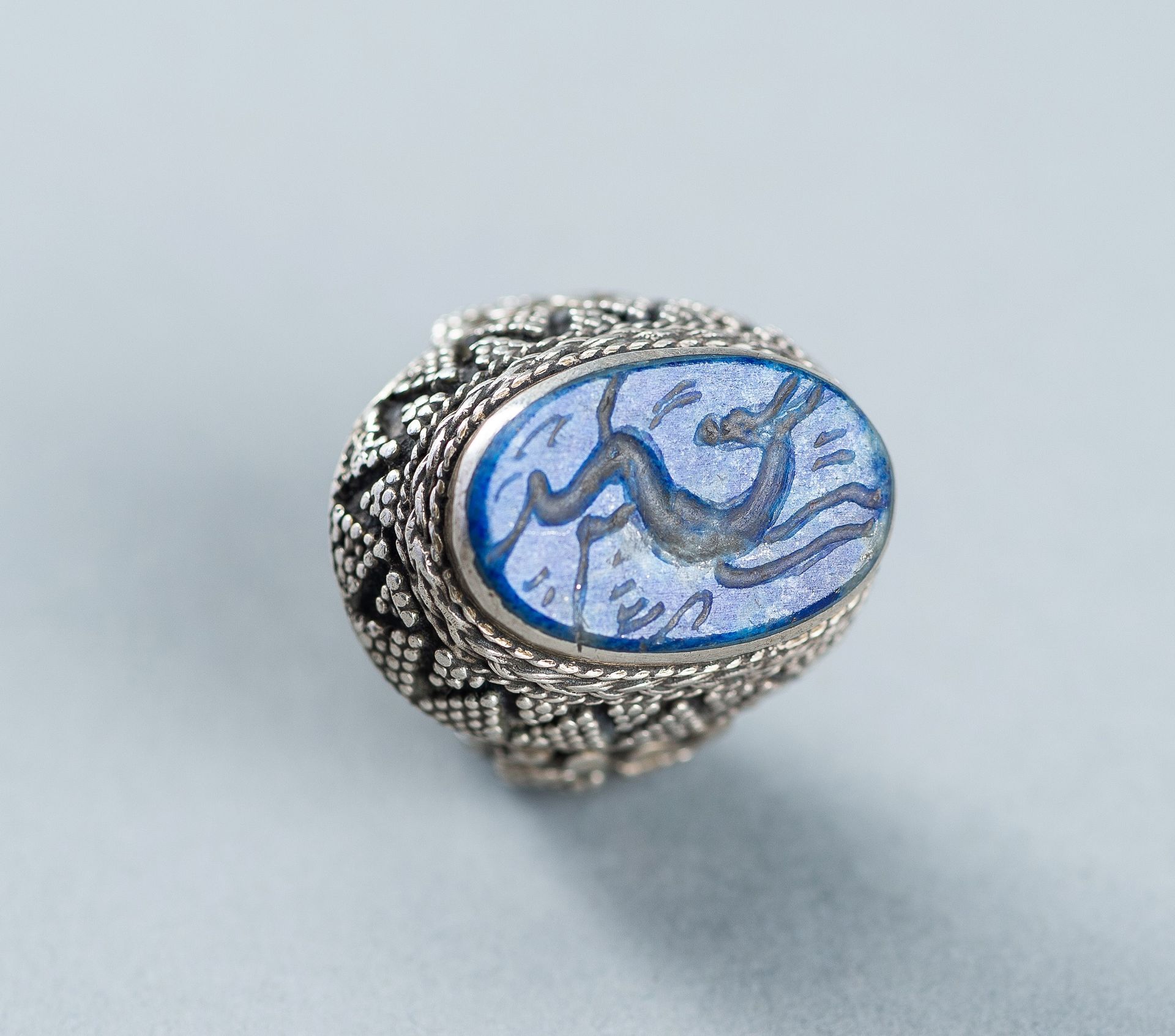 A LAPIS LAZULI INTAGLIO SET PERSIAN SILVER RING