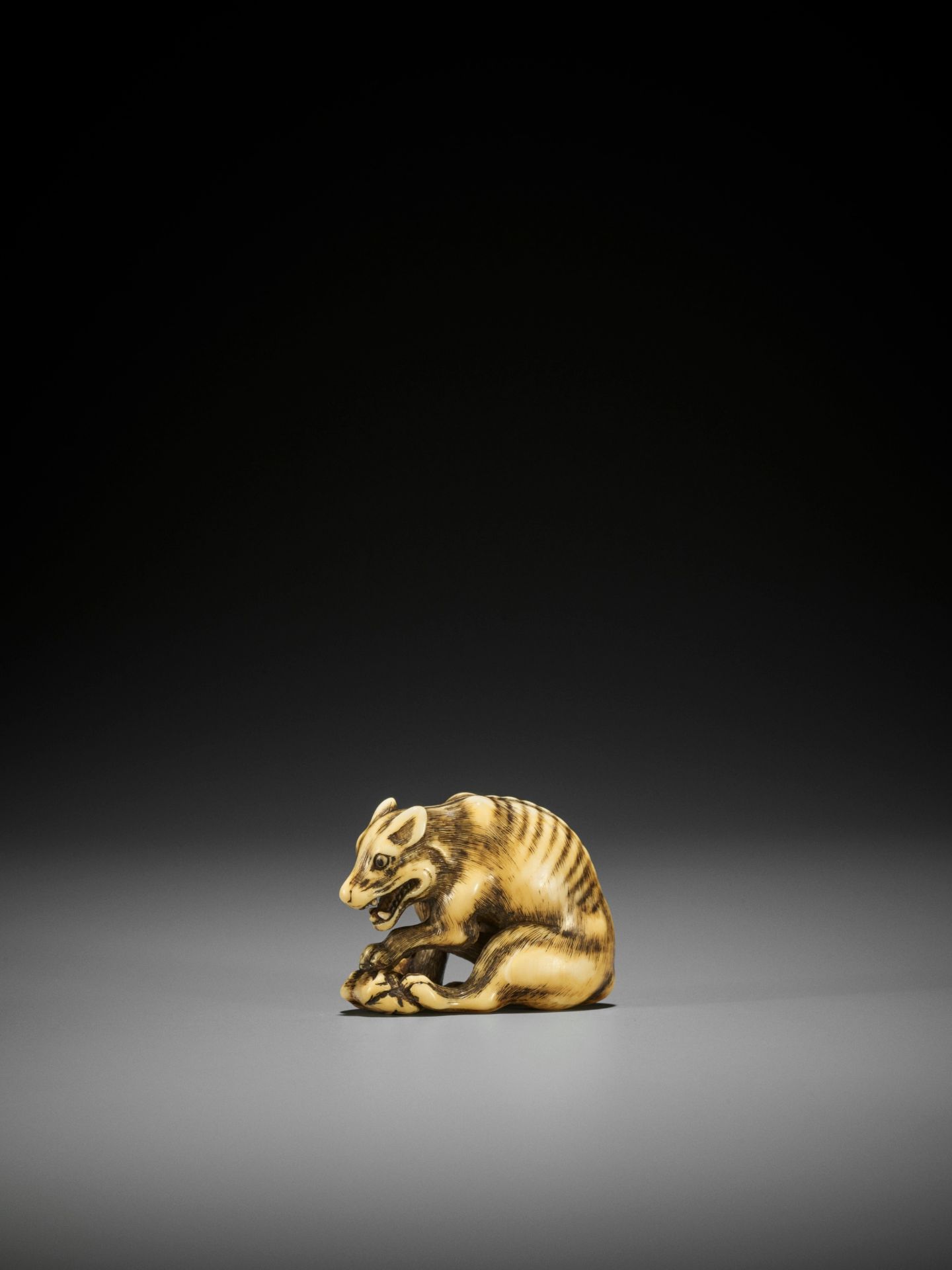TOMOTADA: A FINE IVORY NETSUKE OF A WOLF WITH HAUNCH OF VENISON - Image 4 of 18