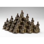 A JAVANESE SCULPTURAL BRONZE GROUP DEPICTING 23 SEATED BUDDHA