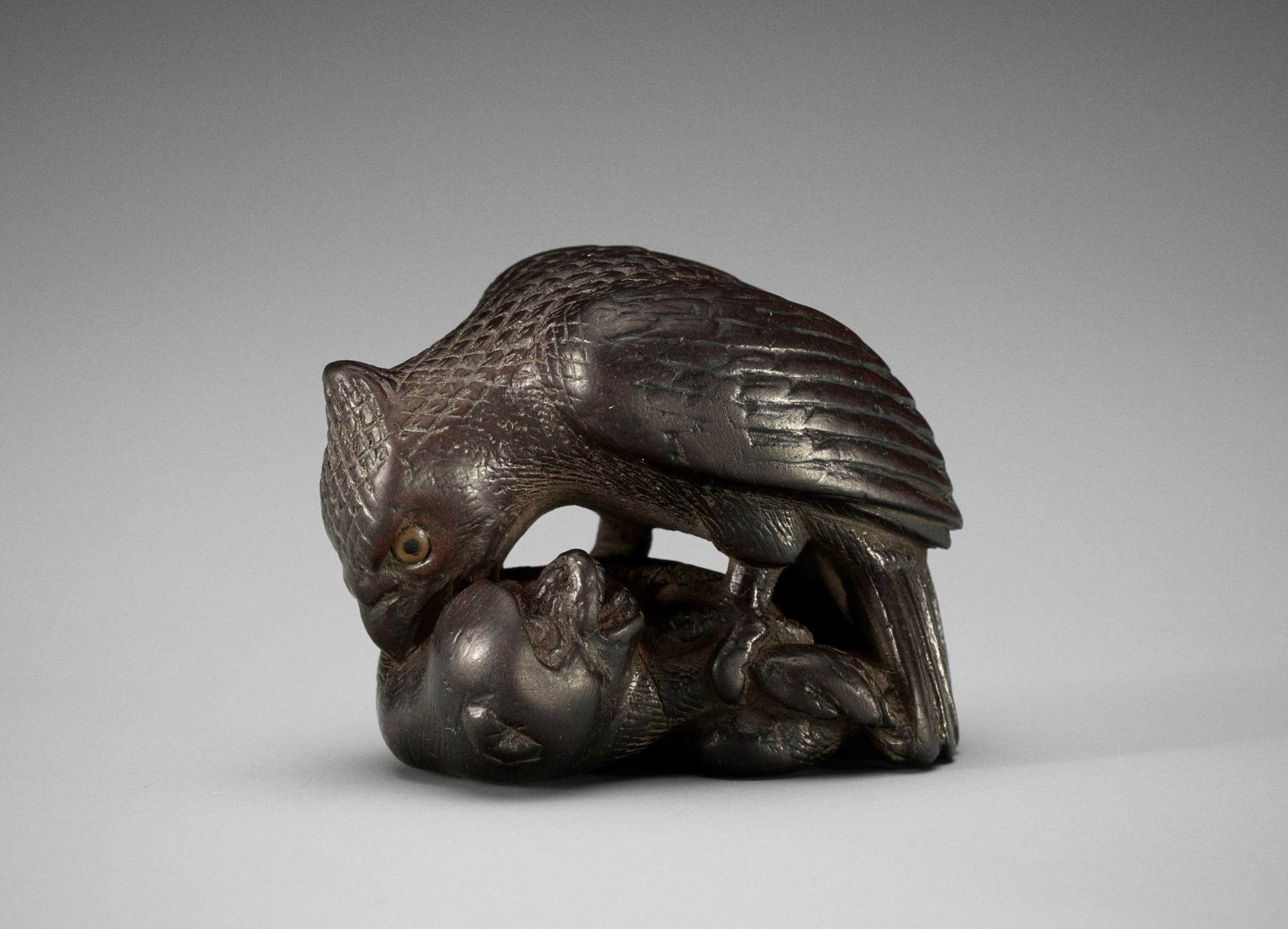 SHINCHUKA: A VERY RARE AND LARGE DARK WOOD NETSUKE OF AN EAGLE SNATCHING A MONKEY